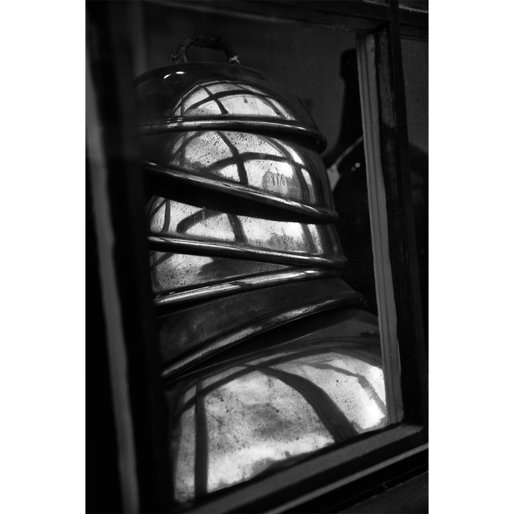 Stack of copper pots depicted in a hand-printed black-and white photograph.