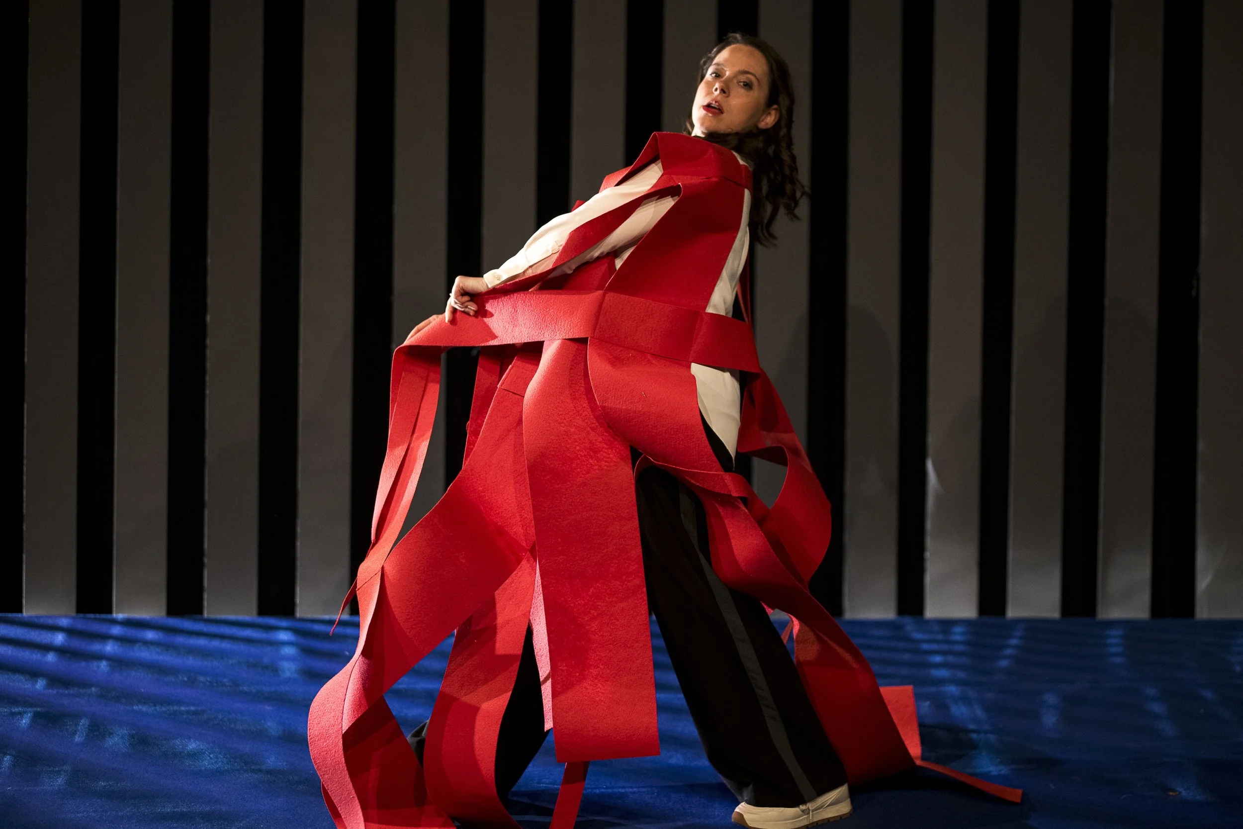 Frau in ausgefallener roter und schwarzer Mode auf Laufsteg