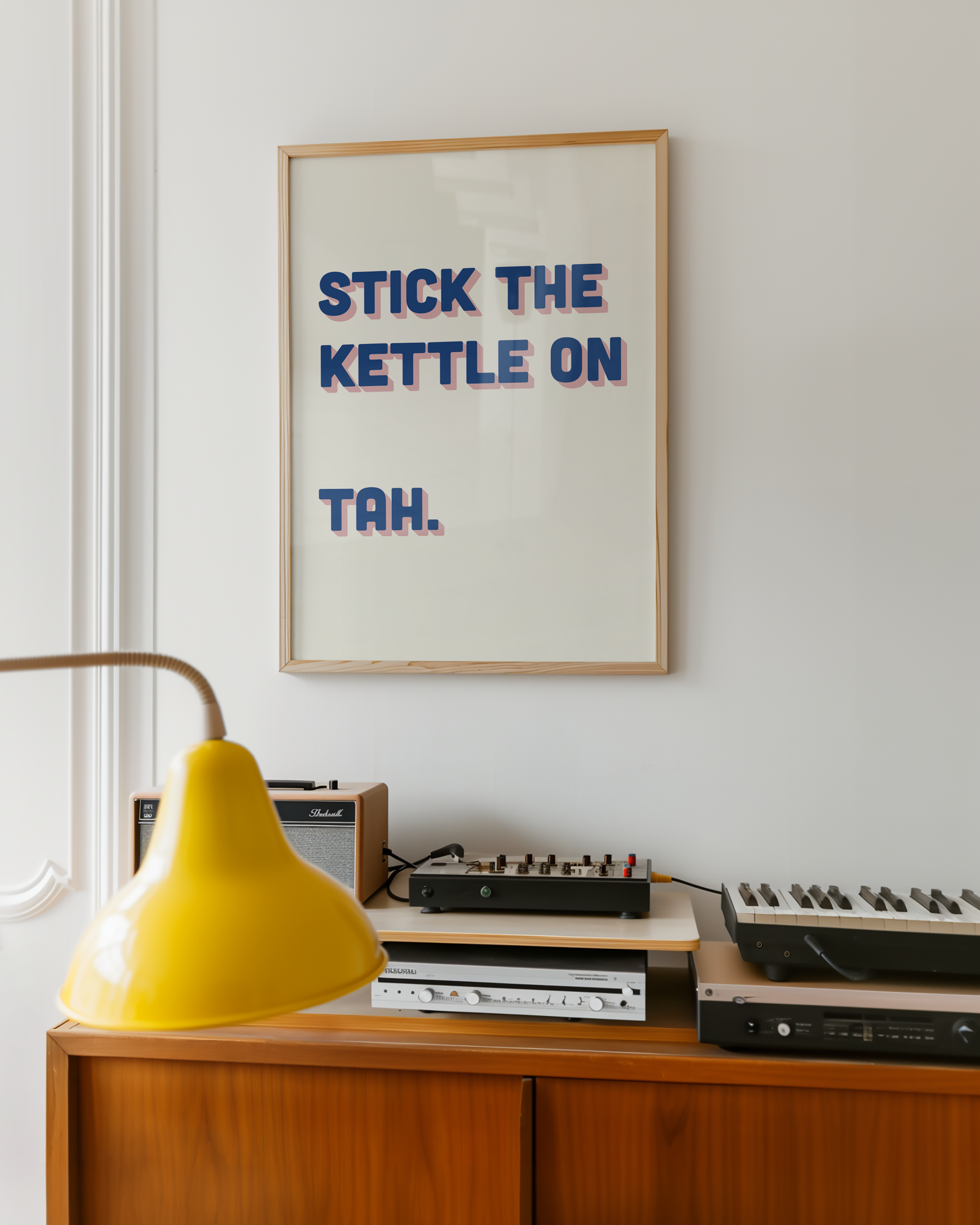 Funny quote print poster that says "Stick the Kettle On Tah" in two tone retro blue and pink font. British humour poster
