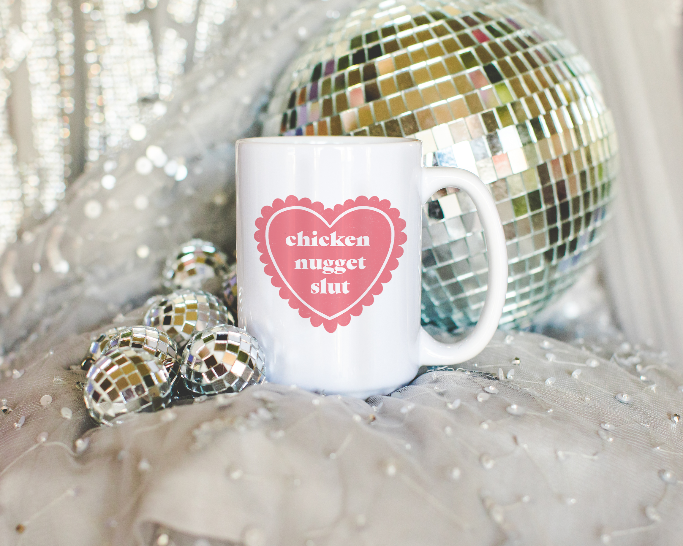 Sassy dopamine decor White coffee mug that says "chicken nugget slut" in a retro vintage style frilly heart that's pink with a retro font.. Available in 11oz and 15oz