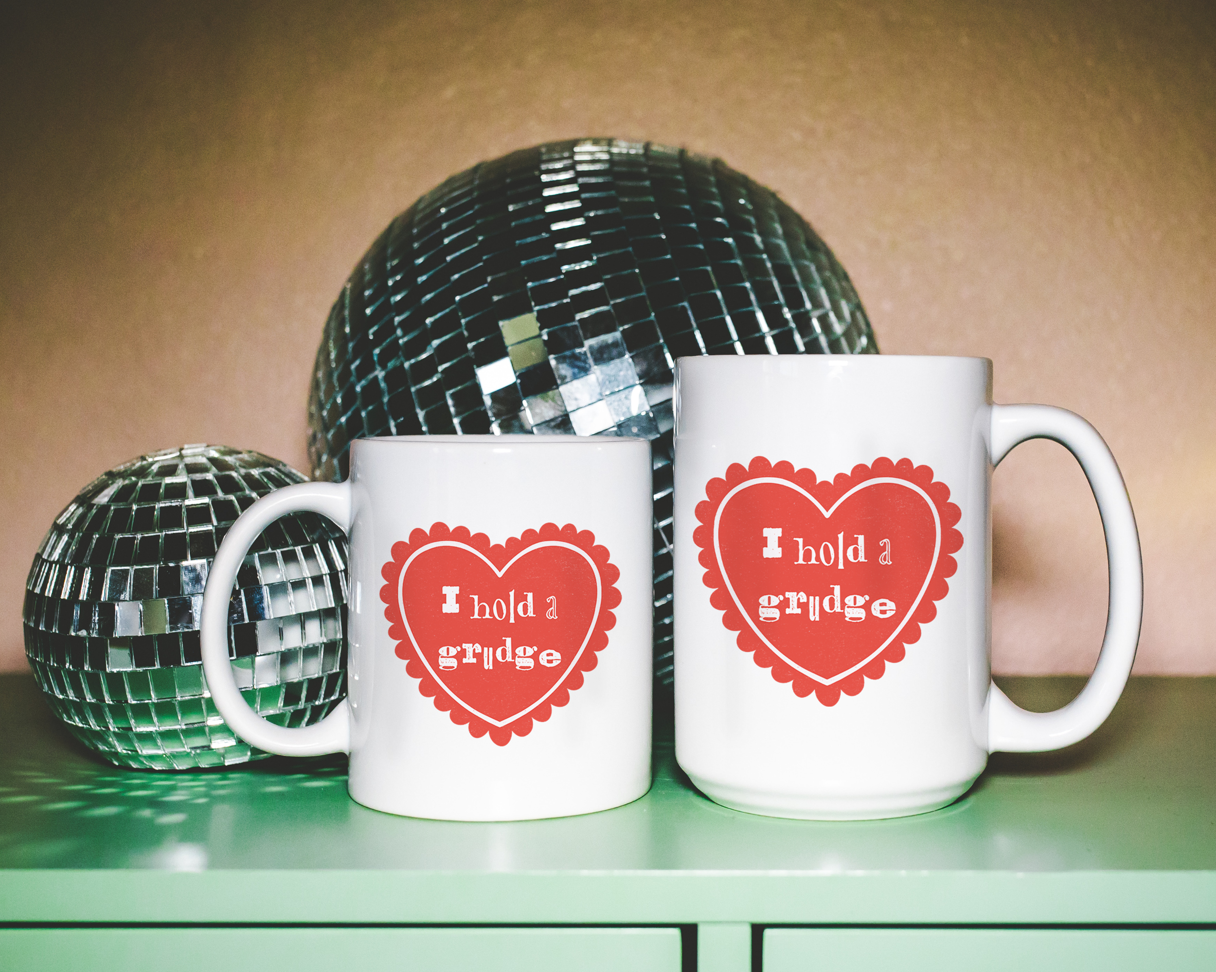Sassy dopamine decor White coffee mug that says "I hold a grudge" in a retro vintage style frilly heart that's red with a retro font.. Available in 11oz and 15oz