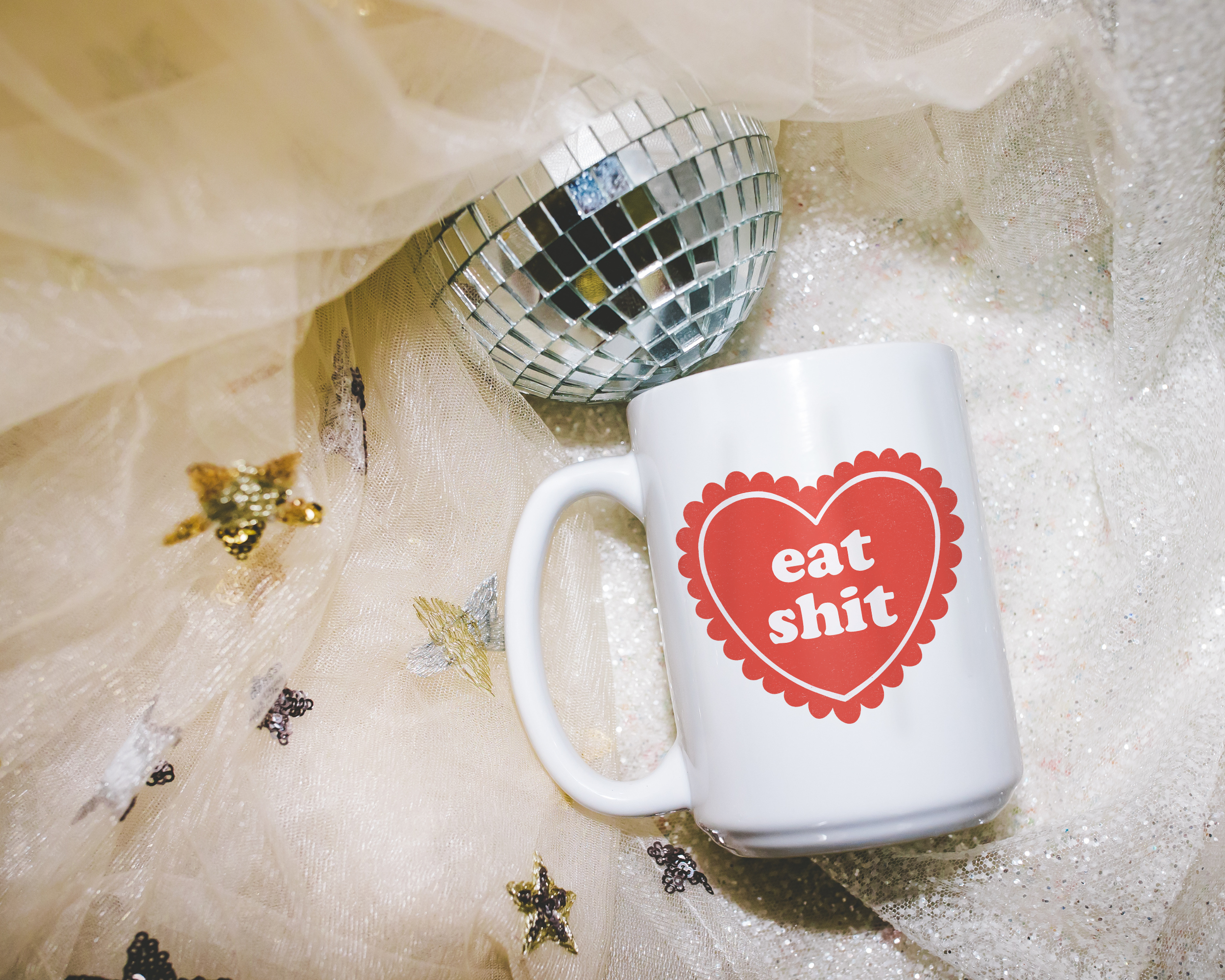Sassy dopamine decor White coffee mug that says "Eat shit" in a retro vintage style frilly heart that's red with a retro font.. Available in 11oz and 15oz