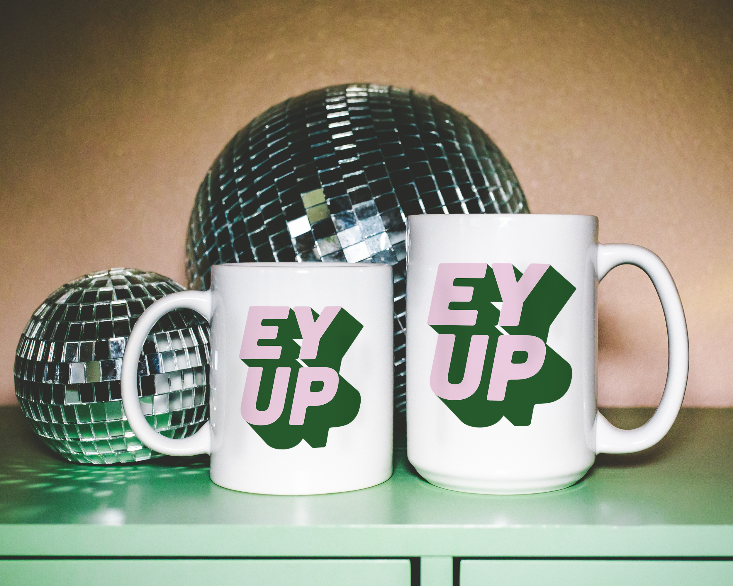 Sassy dopamine decor White coffee mug that says "ey up" in a retro two tone vintage style pink and green font. Available in 11oz and 15oz. British humour