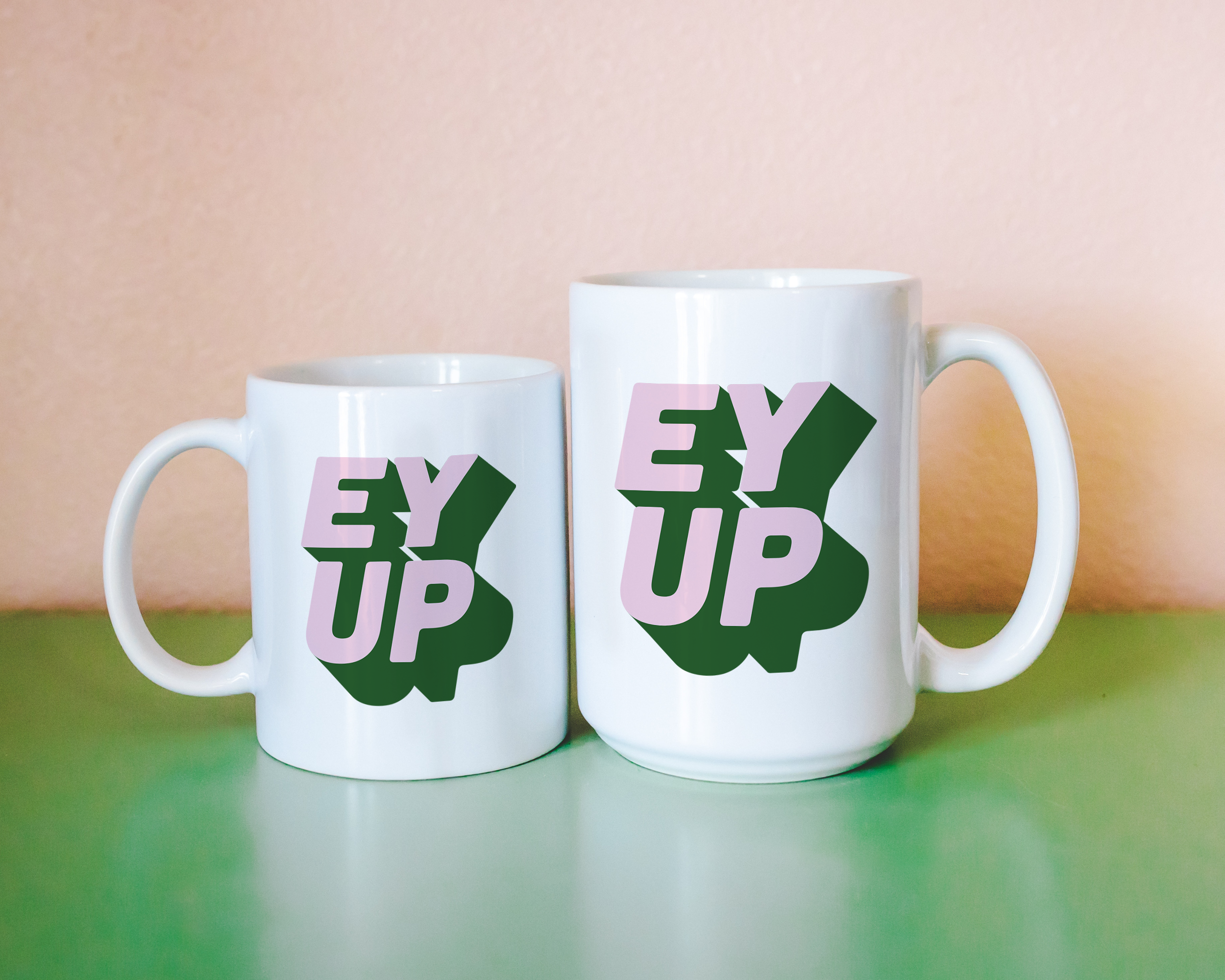 Sassy dopamine decor White coffee mug that says "ey up" in a retro two tone vintage style pink and green font. Available in 11oz and 15oz. British humour