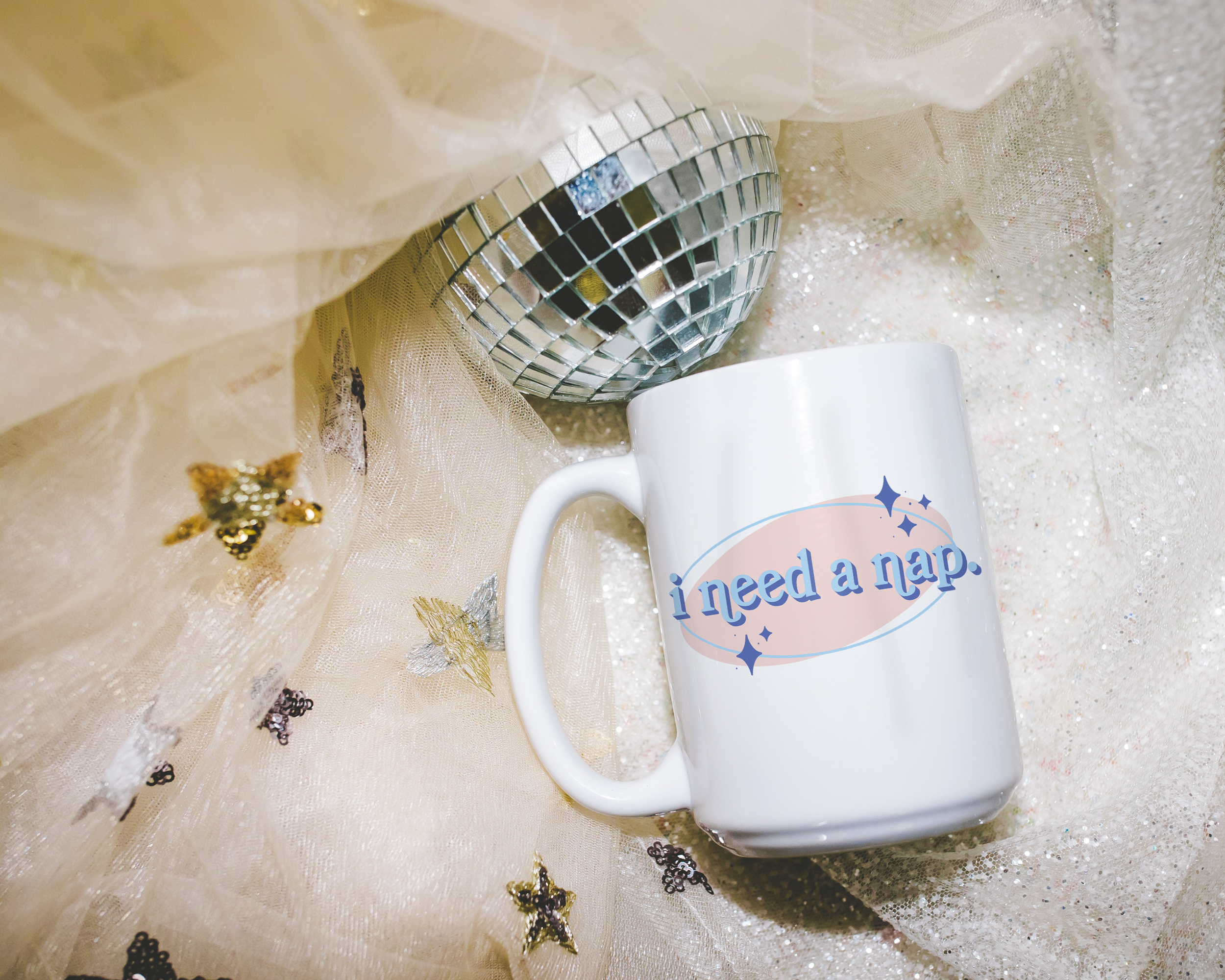 White coffee mug that says "I need a nap" in a retro vintage font that's blue and pink. Available in 11oz and 15oz