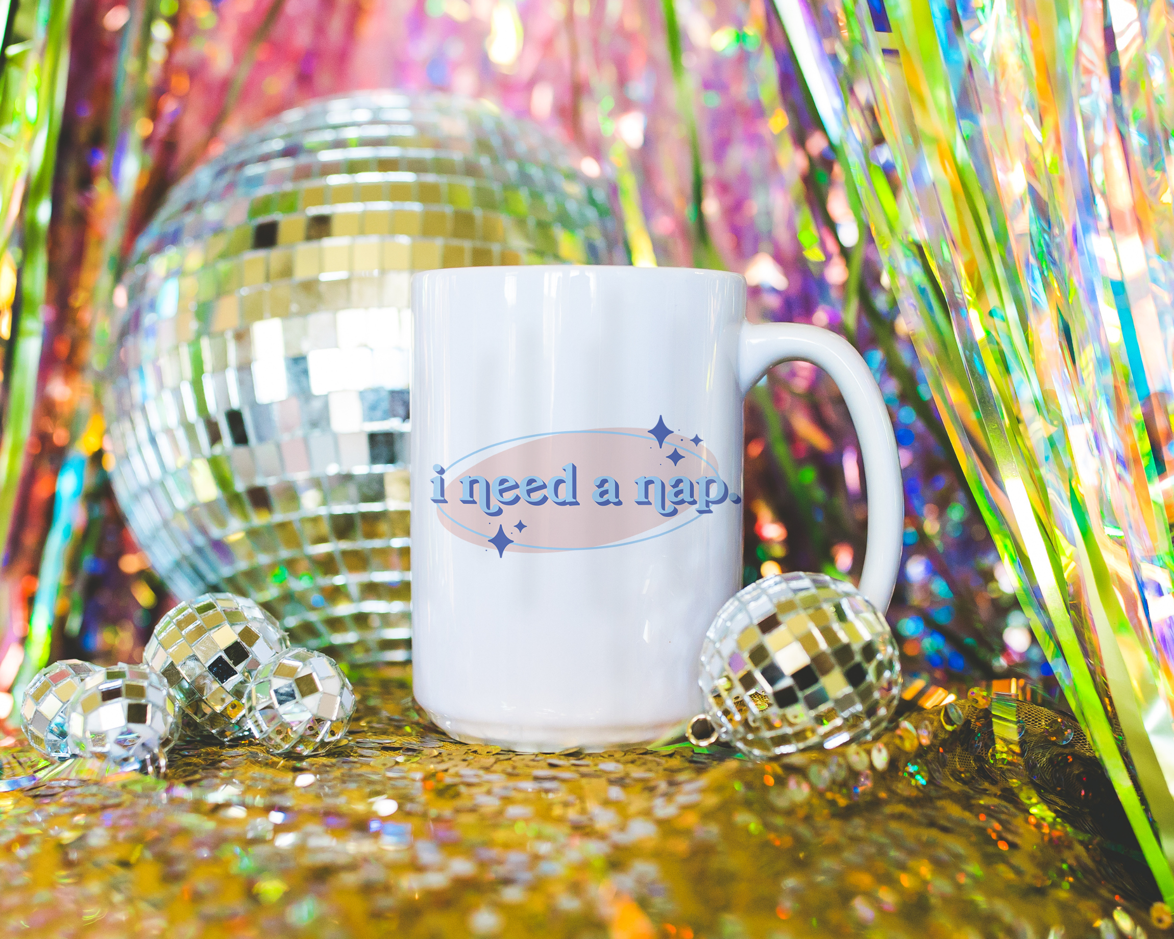 White coffee mug that says "I need a nap" in a retro vintage font that's blue and pink. Available in 11oz and 15oz