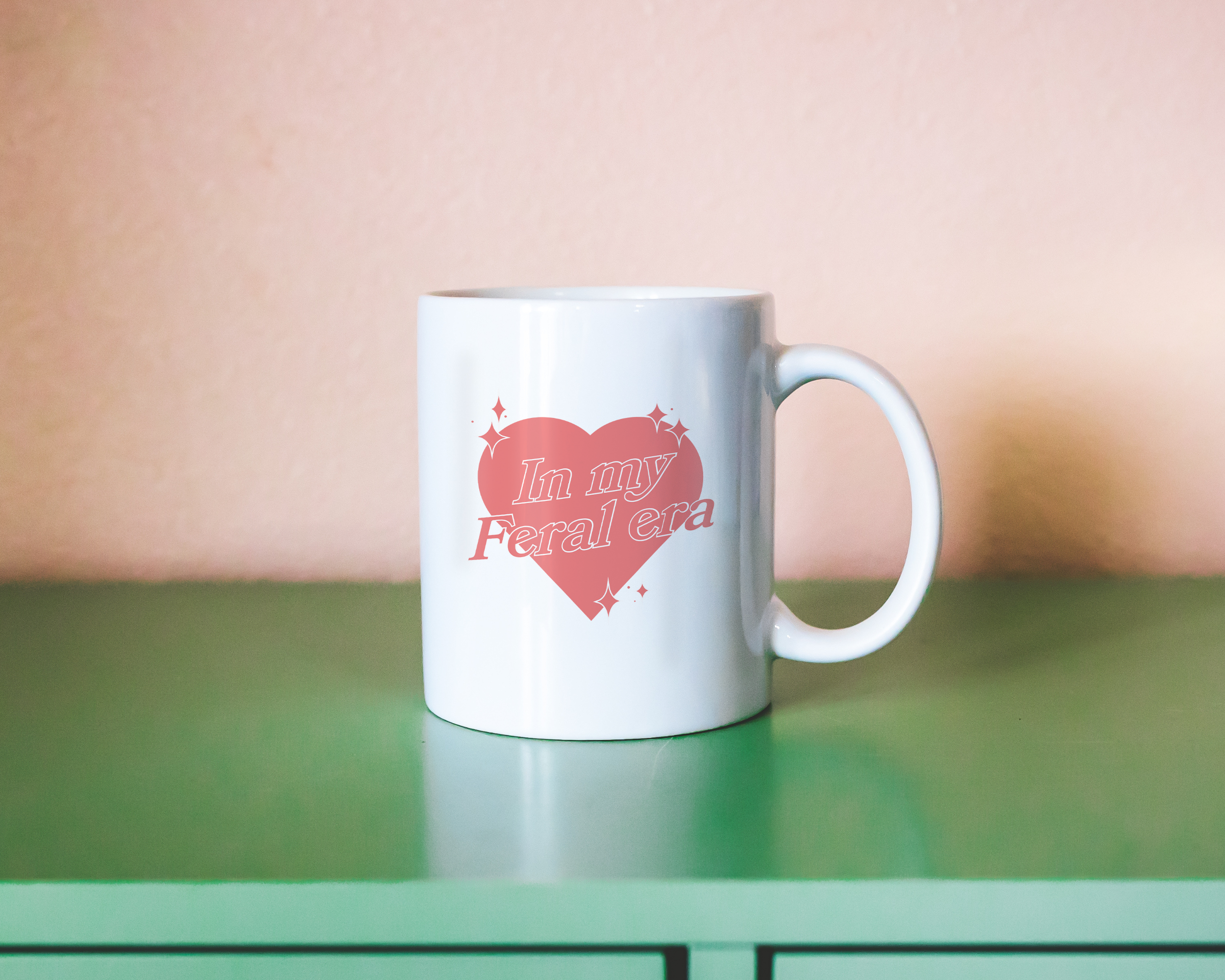 Sassy dopamine decor White coffee mug that says "In my feral era" in a retro vintage style heart that's pink with a retro font.. Available in 11oz and 15oz