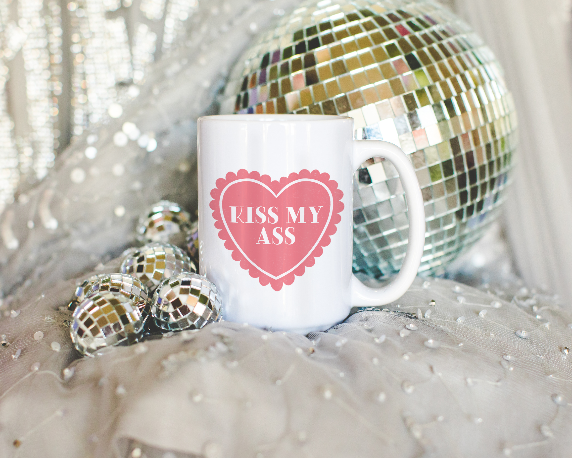 Sassy dopamine decor White coffee mug that says "kiss my ass" in a retro vintage style frilly heart that's pink with a retro font.. Available in 11oz and 15oz