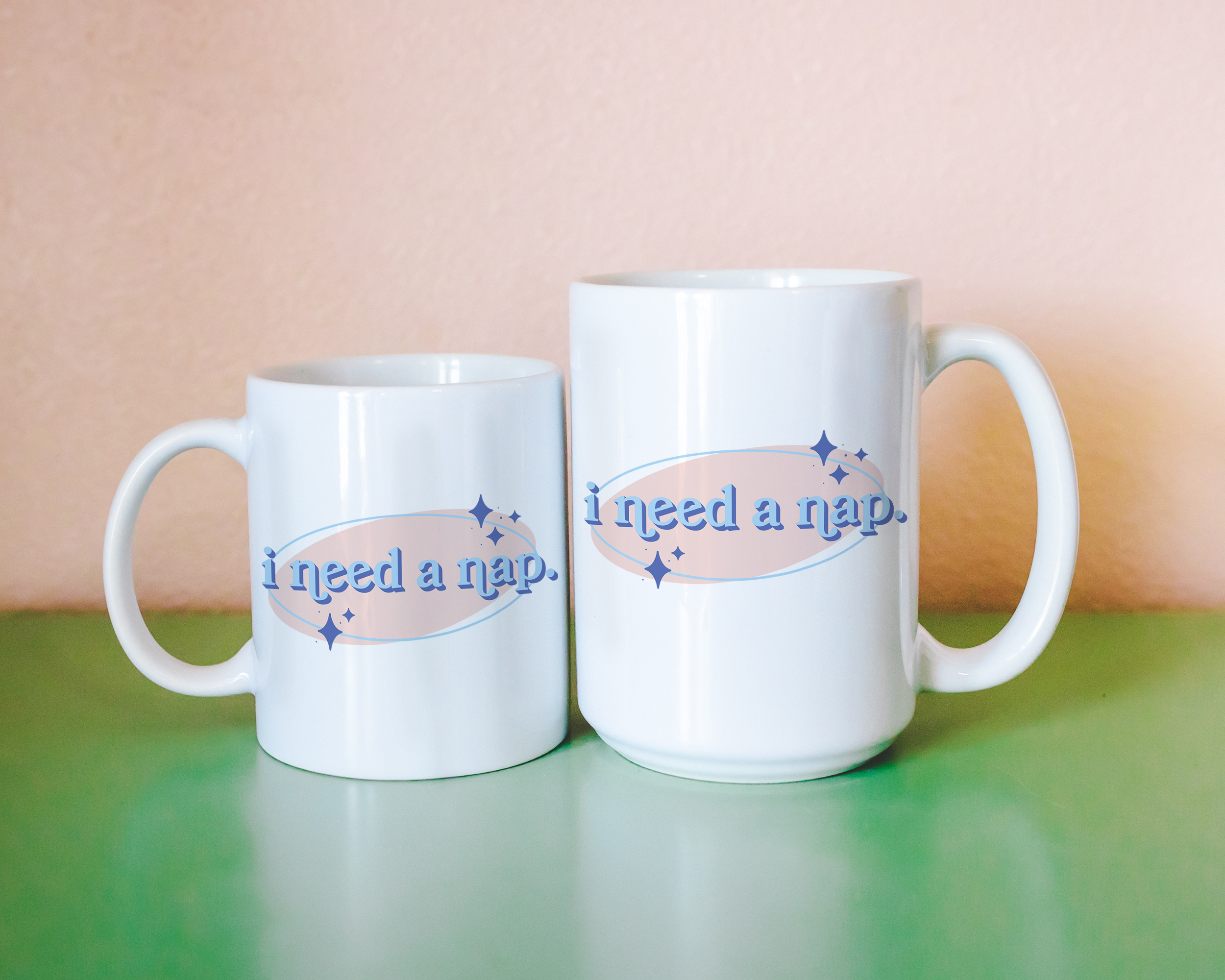 White coffee mug that says "I need a nap" in a retro vintage font that's blue and pink. Available in 11oz and 15oz