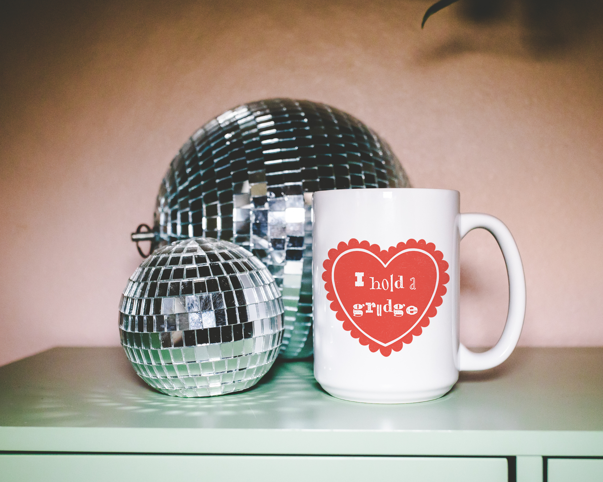 Sassy dopamine decor White coffee mug that says "I hold a grudge" in a retro vintage style frilly heart that's red with a retro font.. Available in 11oz and 15oz