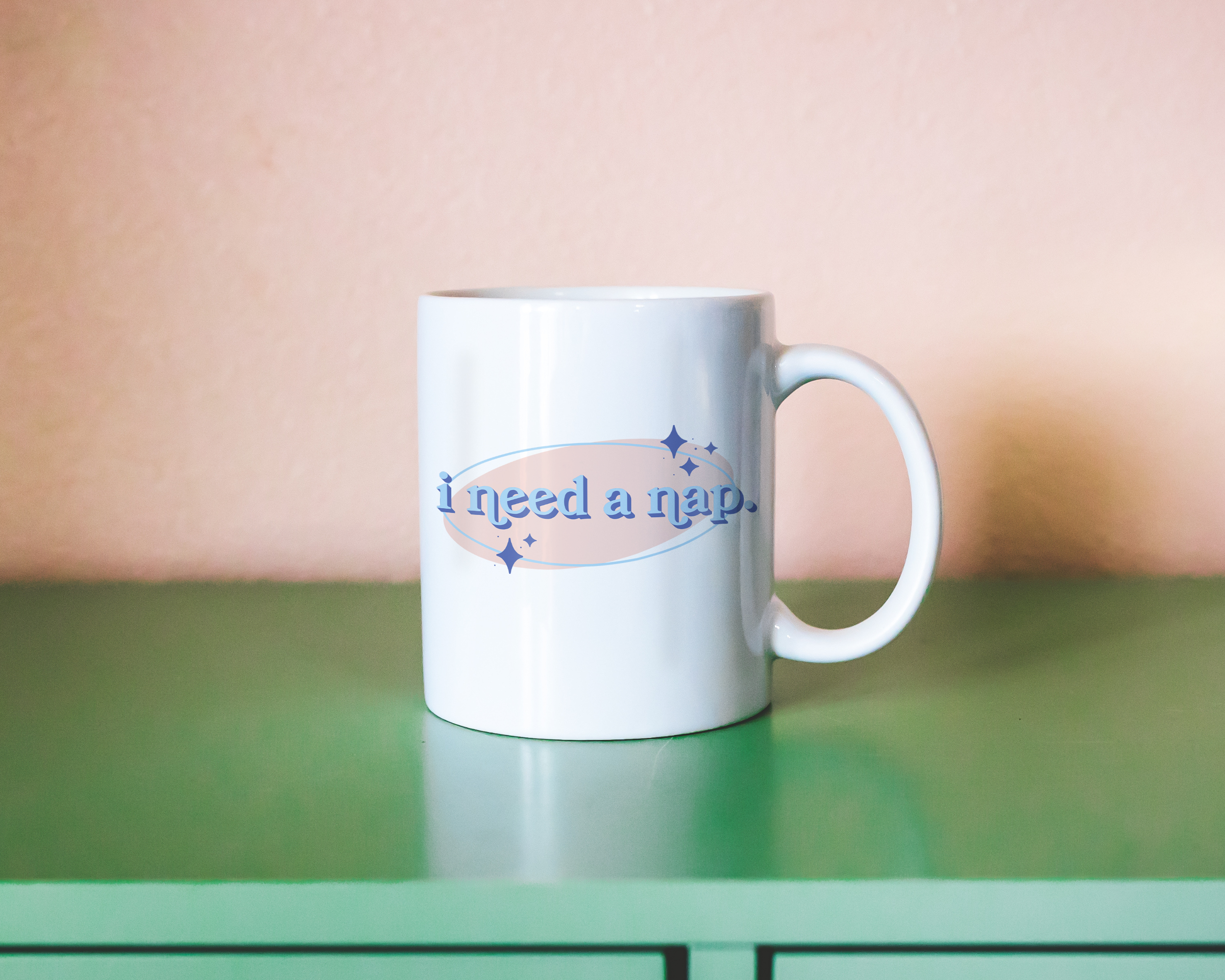 White coffee mug that says "I need a nap" in a retro vintage font that's blue and pink. Available in 11oz and 15oz