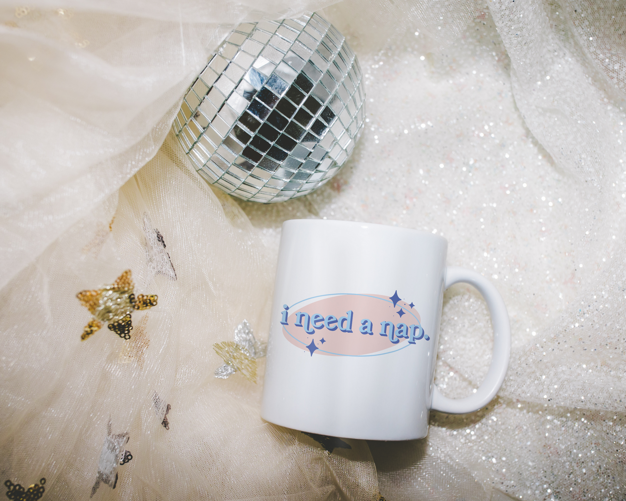White coffee mug that says "I need a nap" in a retro vintage font that's blue and pink. Available in 11oz and 15oz