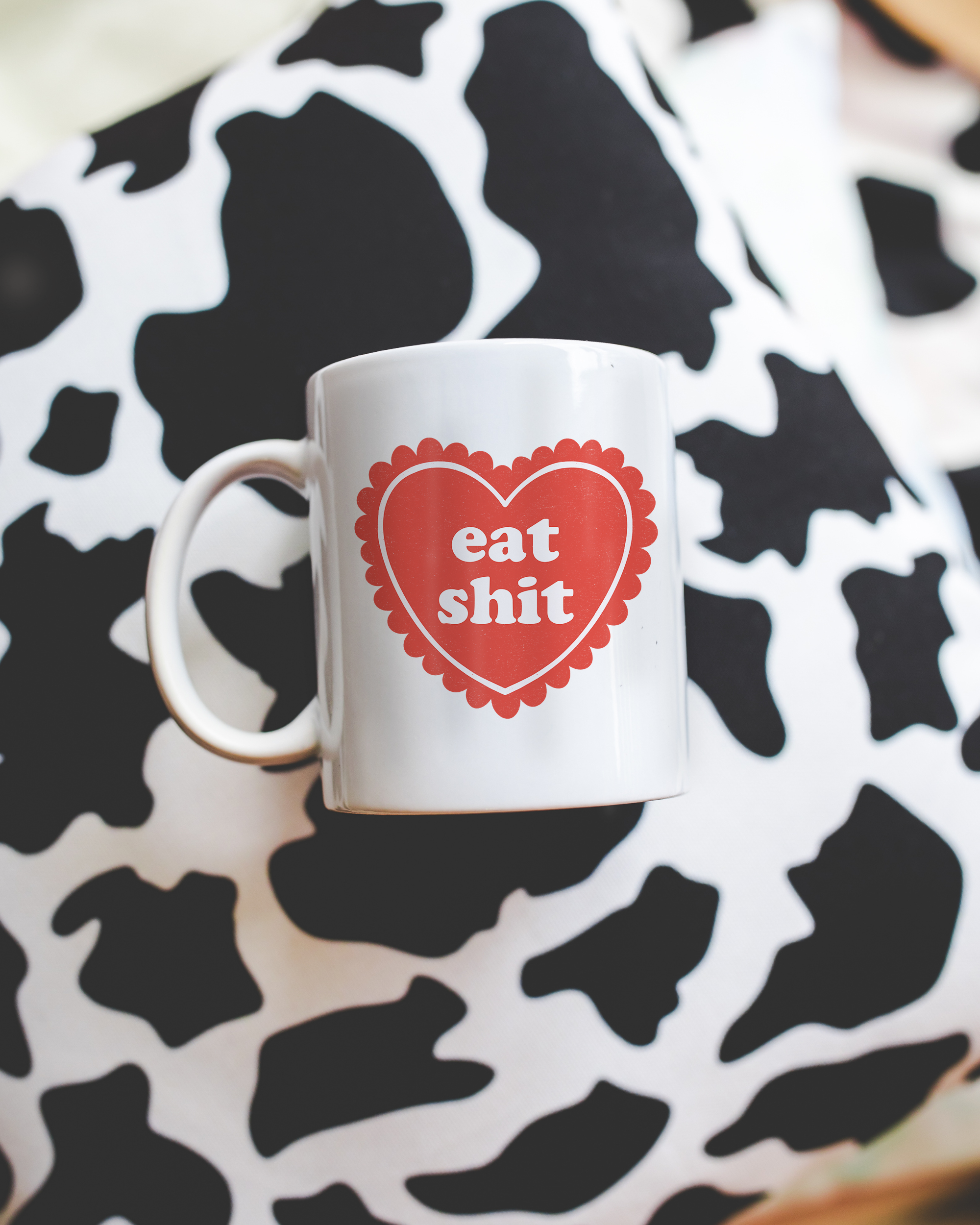 Sassy dopamine decor White coffee mug that says "Eat shit" in a retro vintage style frilly heart that's red with a retro font.. Available in 11oz and 15oz