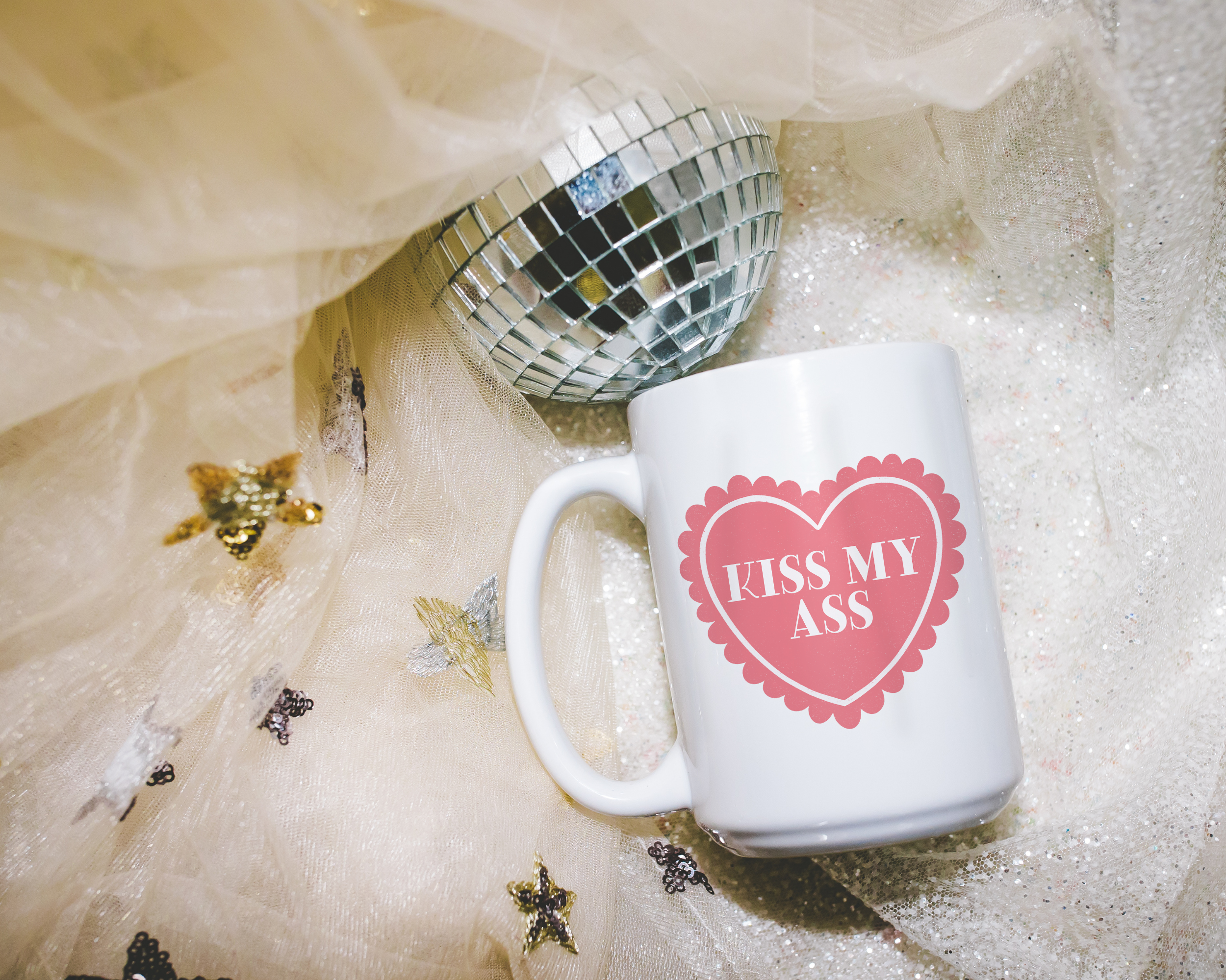 Sassy dopamine decor White coffee mug that says "kiss my ass" in a retro vintage style frilly heart that's pink with a retro font.. Available in 11oz and 15oz