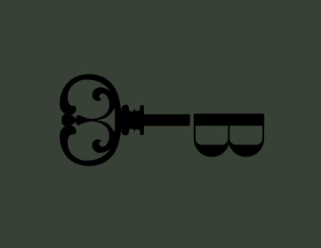 A black, ornate vintage key on a dark green background.