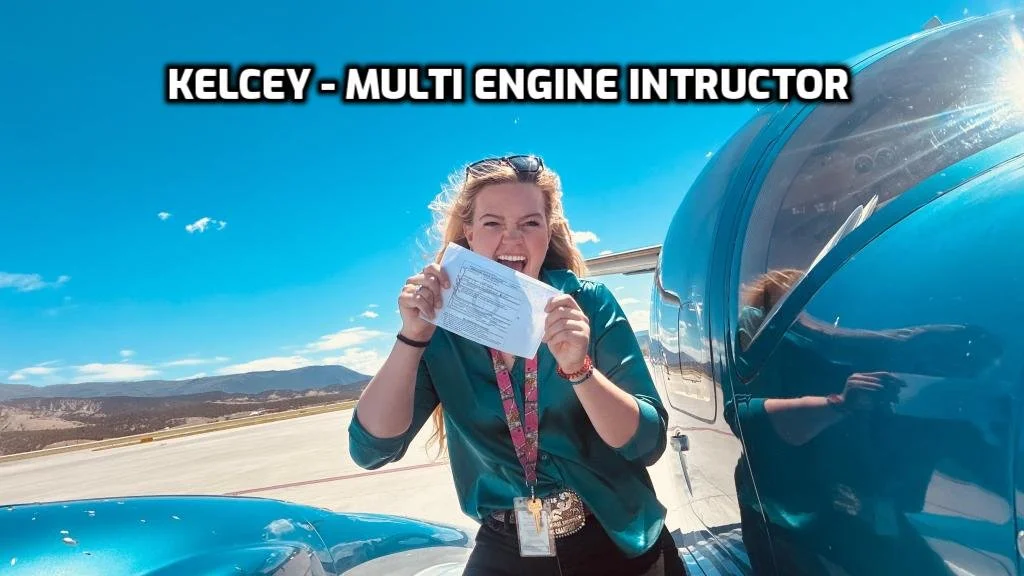 A woman smiling and holding a sheet of paper stands next to a blue aircraft on a tarmac with mountains and a blue sky in the background, during daytime, with the text "KELCEY - MULTI ENGINE INSTRUCTOR" at the top.