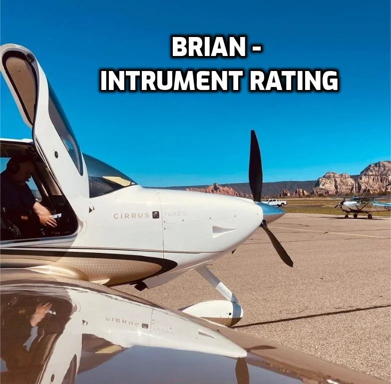 A white and silver Cirrus Turbo airplane on an airport tarmac, with a clear blue sky and mountains in the background. The image includes the text 'BRIAN - INSTRUMENT RATING'.