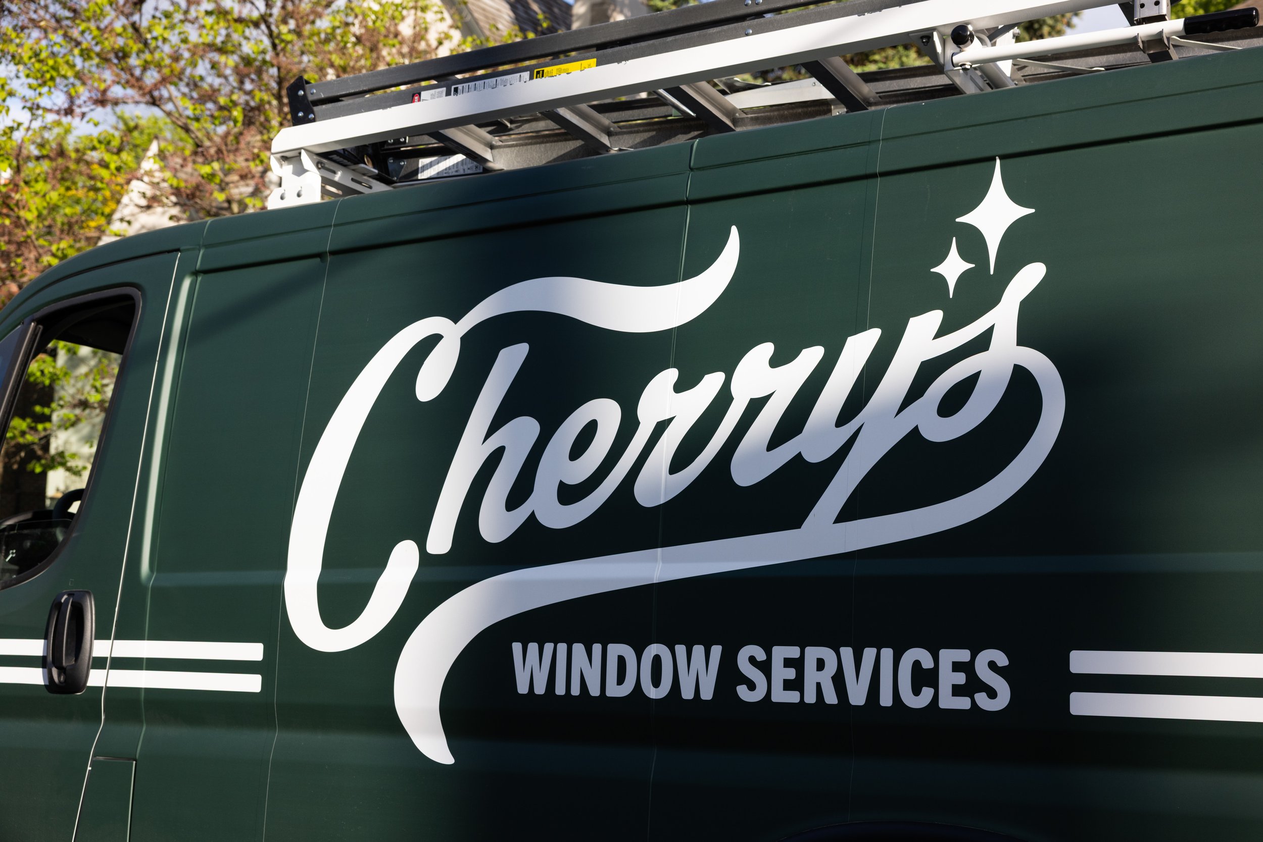 Green van with white lettering that reads 'Cherub Window Services' and a star graphic on the side