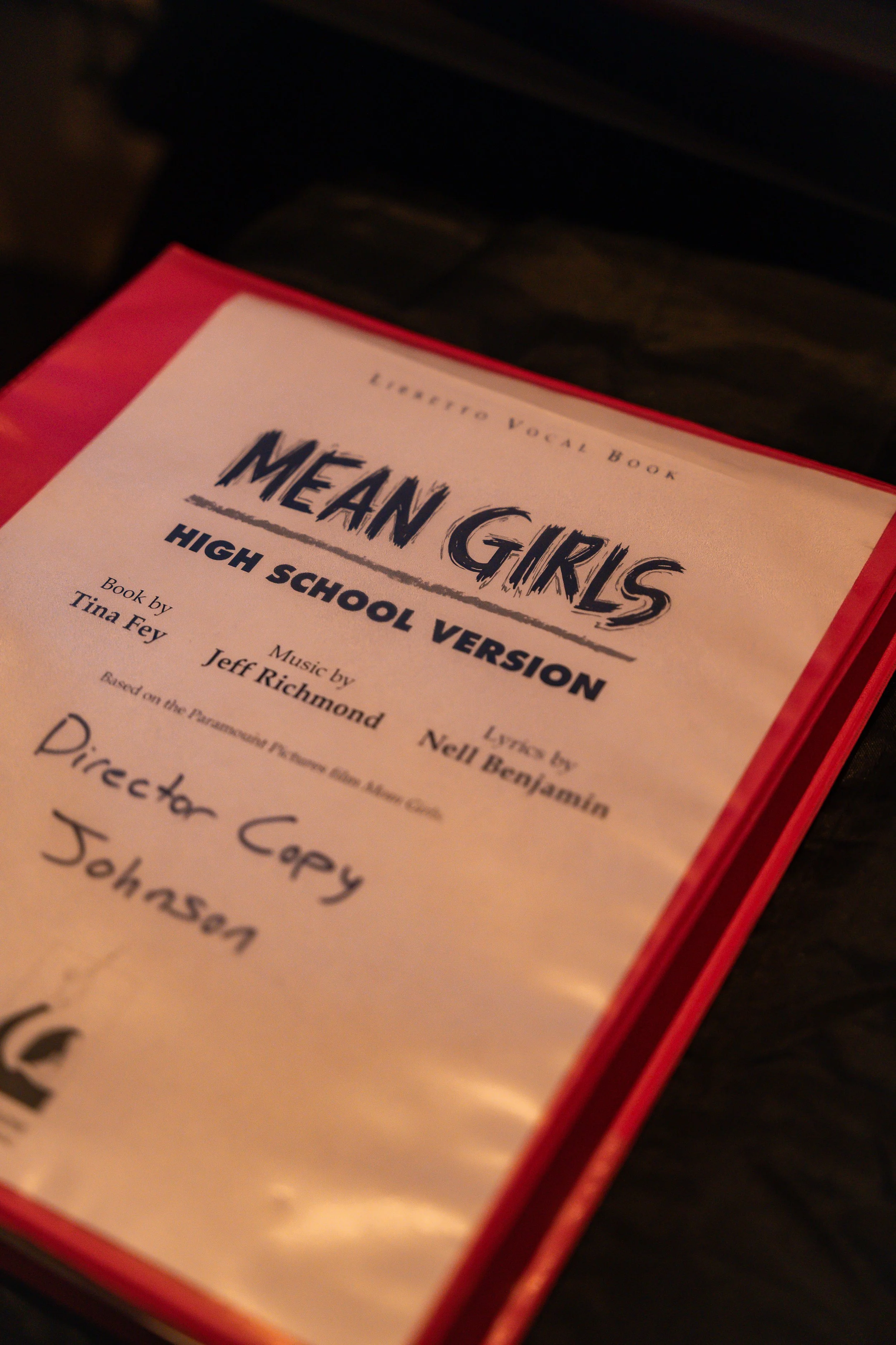 A program for the musical 'Mean Girls' high school version, with credits for book by Tina Fey, music by Jeff Richmond, lyrics by Nell Benjamin, and directed by Corey.