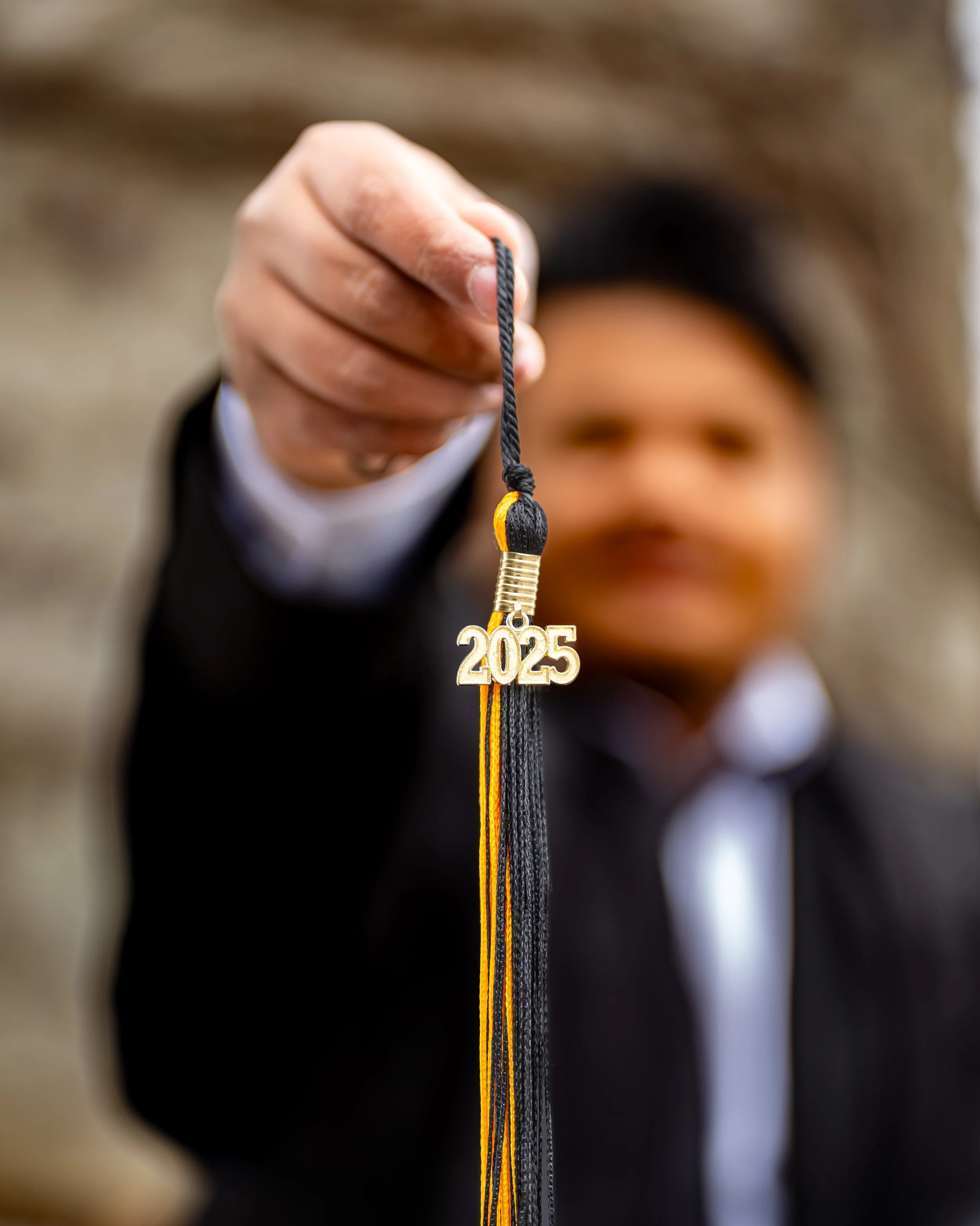 Person holding a graduation cap with a 2025 tassel.