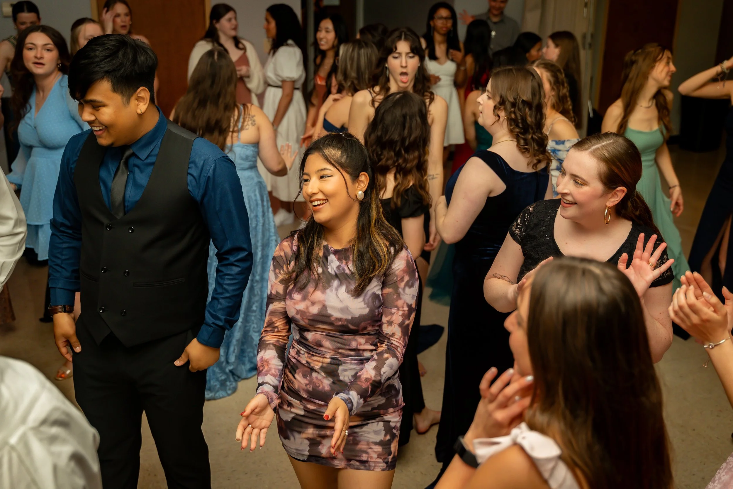 Group of people at a lively party, dancing and socializing, with smiling and surprised expressions.