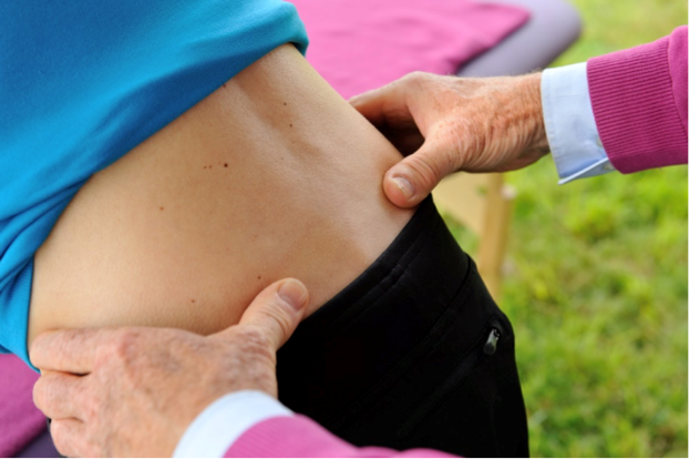 Kontrolle Beckenschiefstand bei der DORNmethode, dazu legt der Therapeut seine Daumen auf die Beckenschaufel