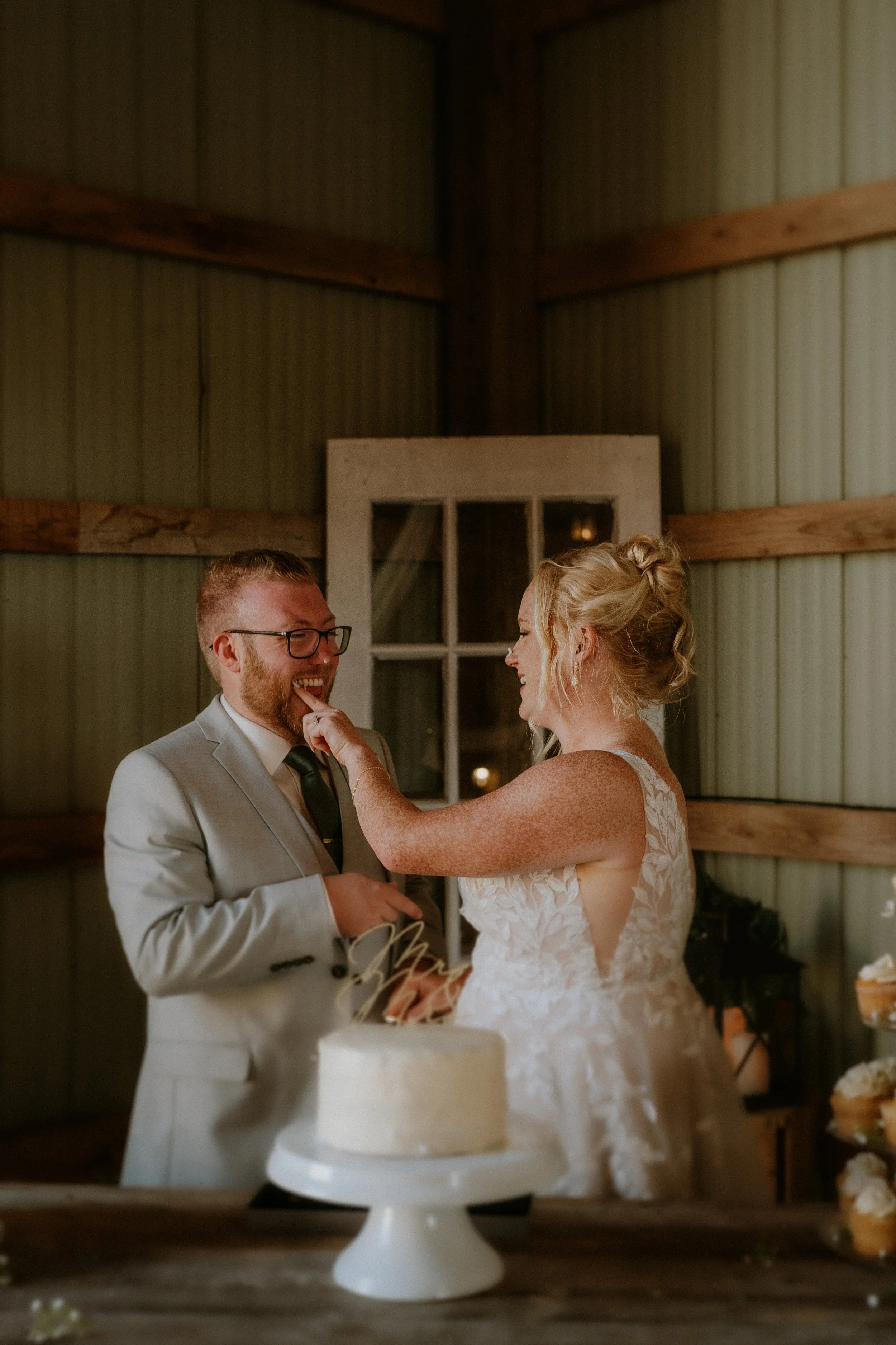 A bride and groom sharing a joyful moment during their wedding celebration, with the bride touching the groom's face.