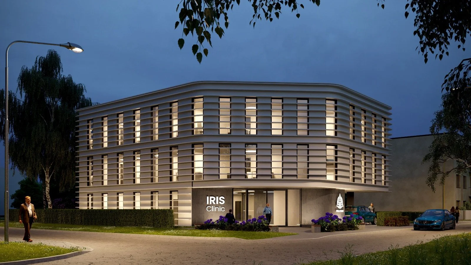 Modern building labeled IRIS Clinic with illuminated windows at dusk, surrounded by trees, cars, and people walking