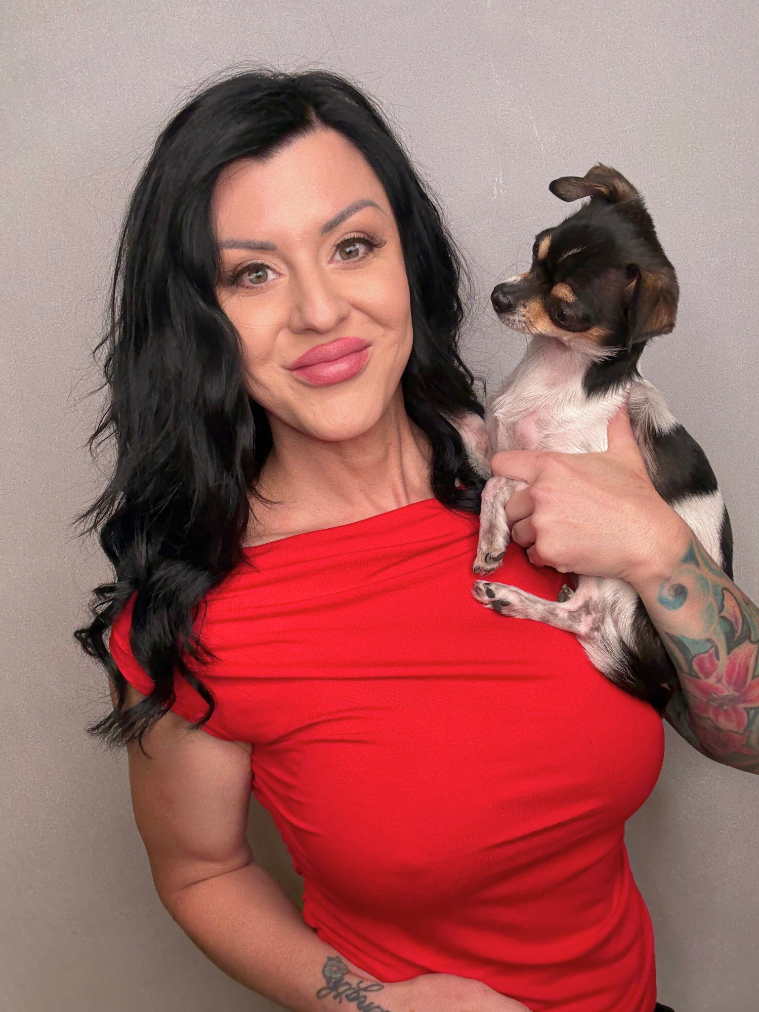 Angela Robinson, mortgage broker in Alberta, smiling while holding her Chihuahua, Ripley, against a neutral backdrop. Personal, friendly brand photo.