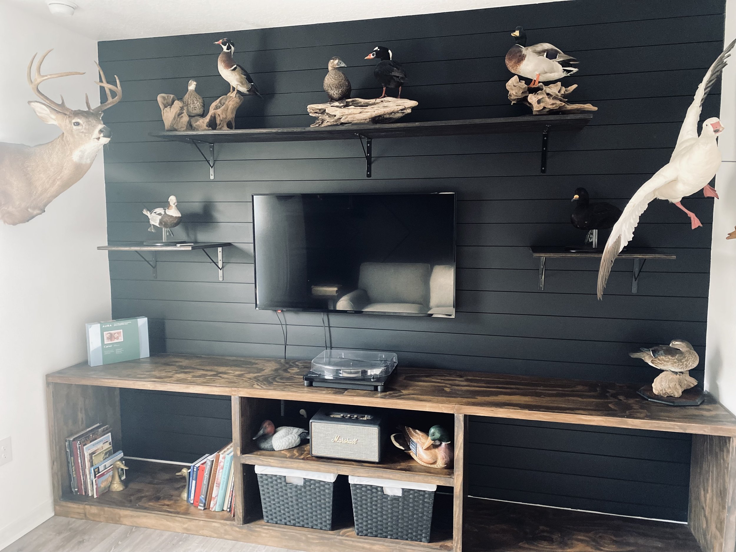shiplap wall with customer entertainment center and shelving for man-cave