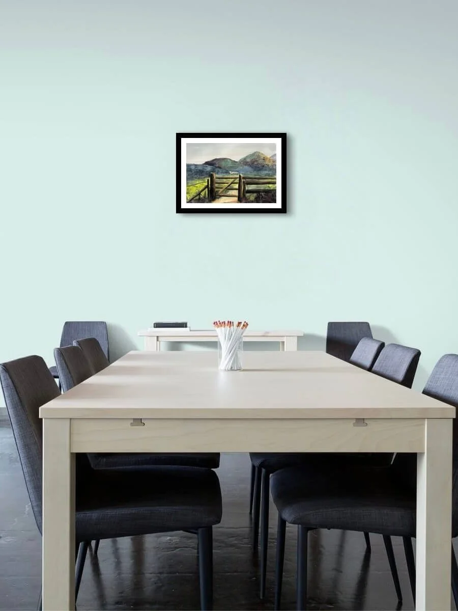 Through The Gate landscape painting by Andrew Bowers hung on an interior wall in a black frame with off white mount