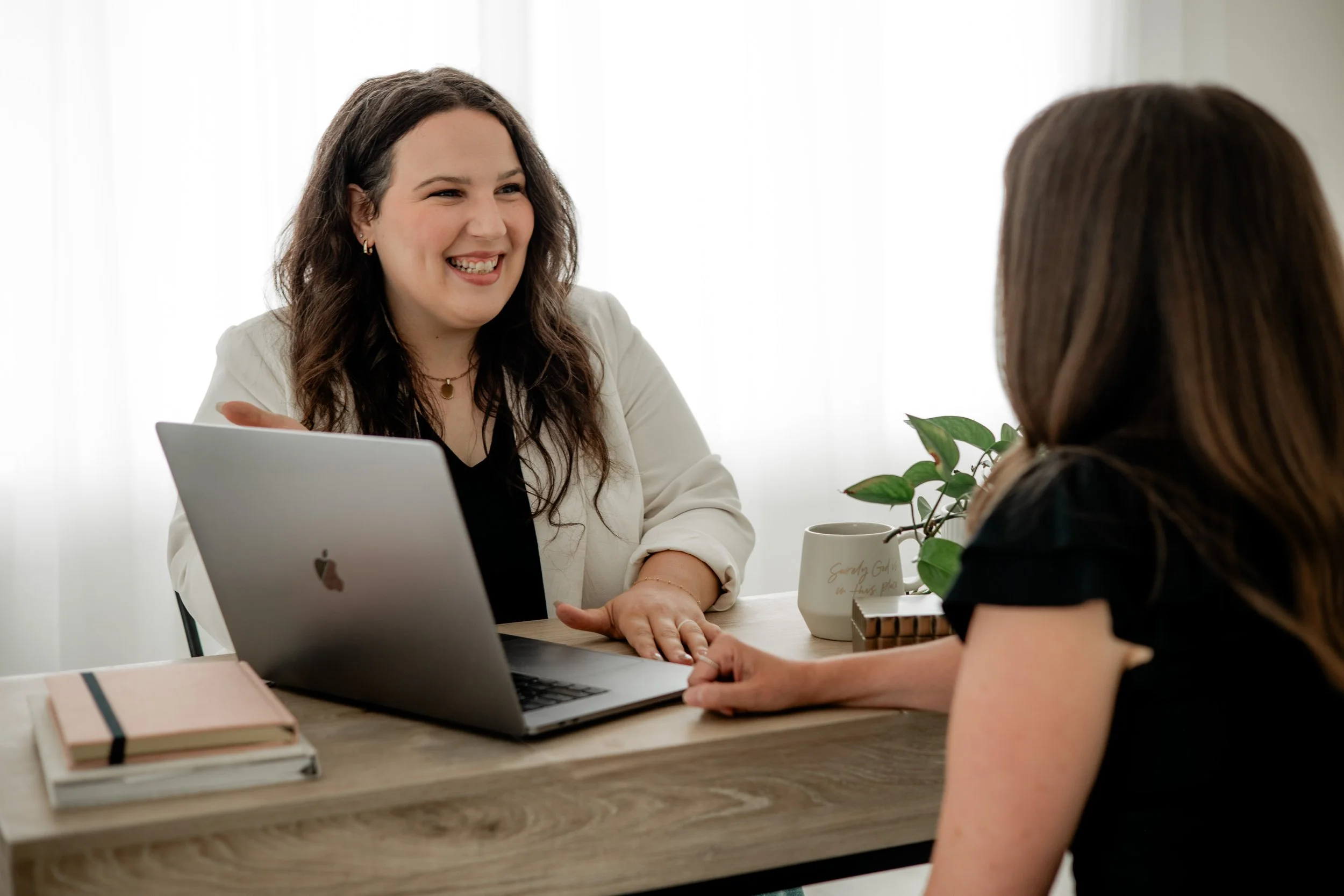 Kayla consulting a client with a text overlay that reads "Purpose-Driven Marketing That Creates Real Impact"