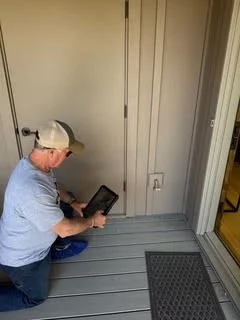 Sisters Home Watch Inspector taking a photo of house exterior to include with weekly report to clients
