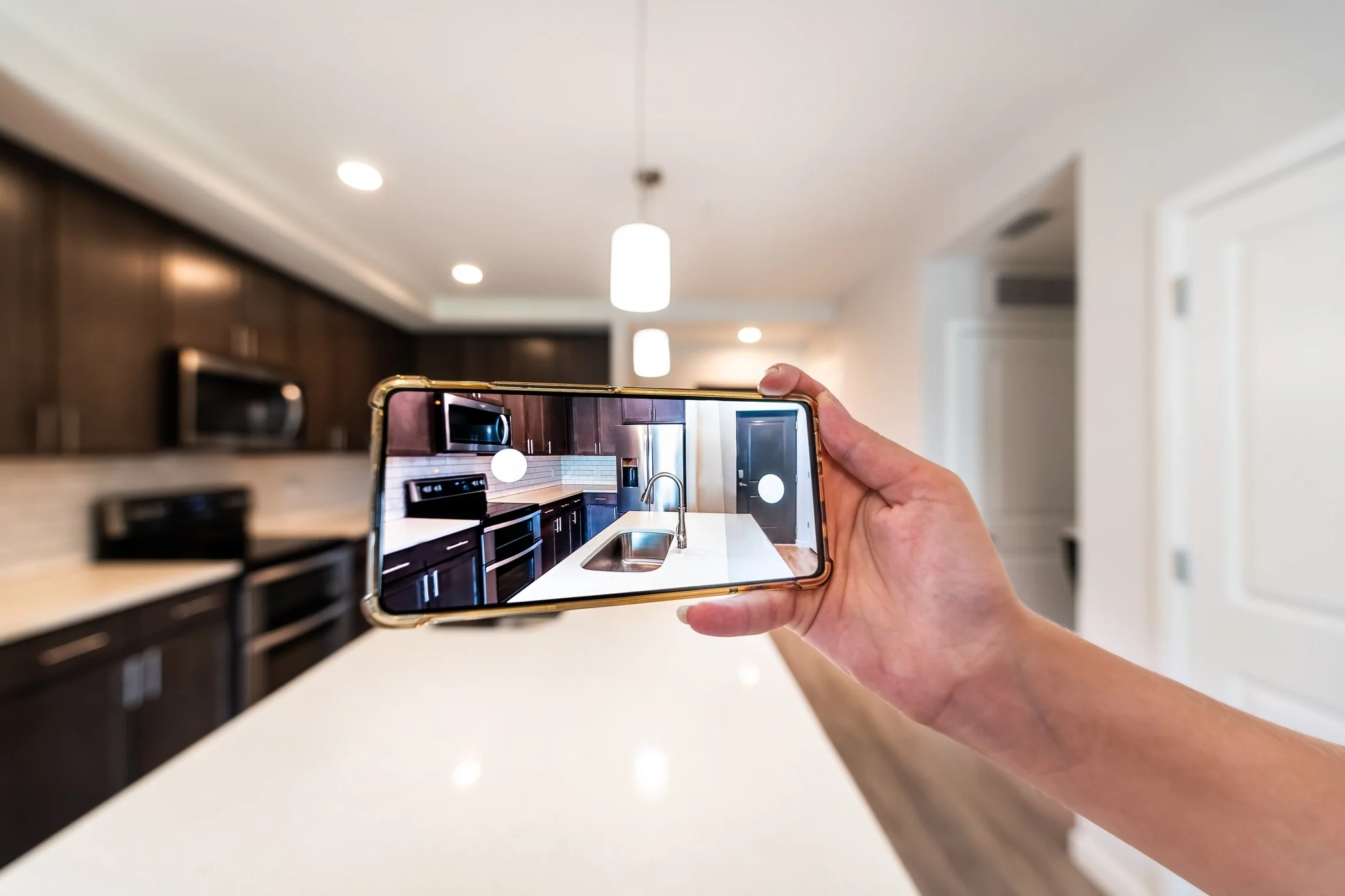 Sisters Home Watch inspector taking a photo of the kitchen to share with homeowners