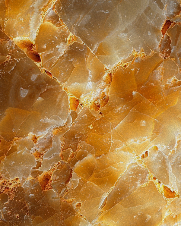 Close-up of a polished, orange and beige onyx stone with intricate veining.