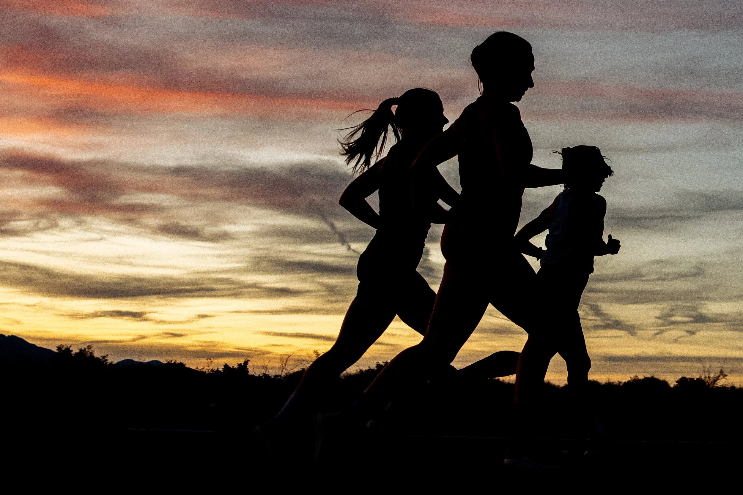 Group of women running at sunset