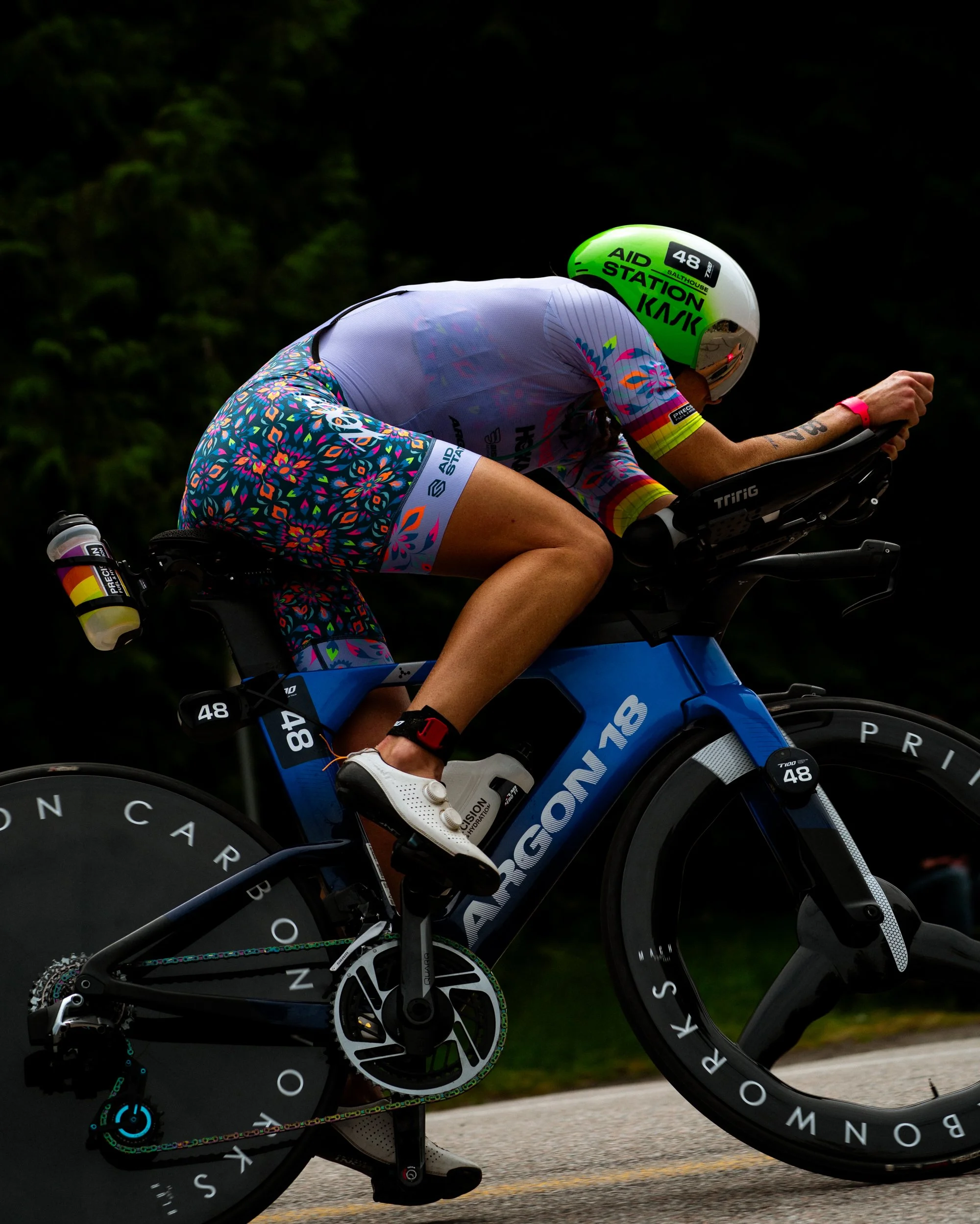 A cyclist in colorful gear riding a blue high-performance racing bike.