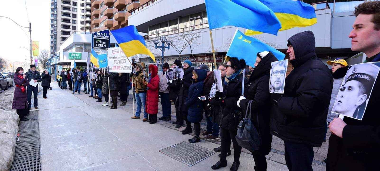 A demonstrator waves the Crimean Tatar flag in solidarity with political prisoners and exiled families.