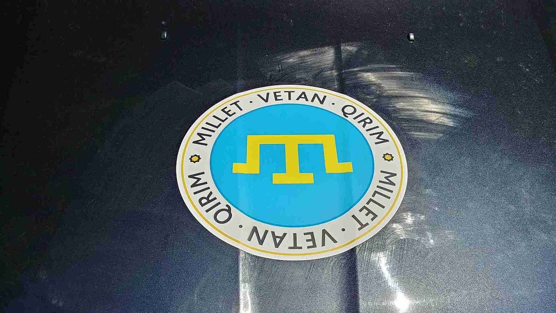Crimean Tatar emblem displayed on a car hood during the Car Rally for Flag Day.