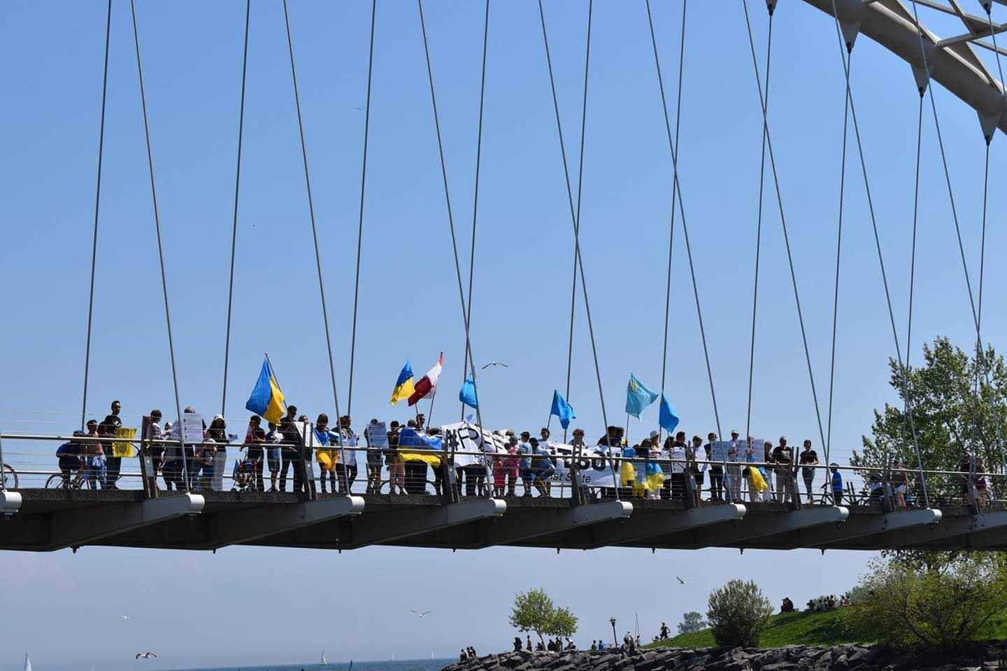 Protesters stand united with a large #FreeSentsov banner, demanding the release of the imprisoned Ukrainian filmmaker.