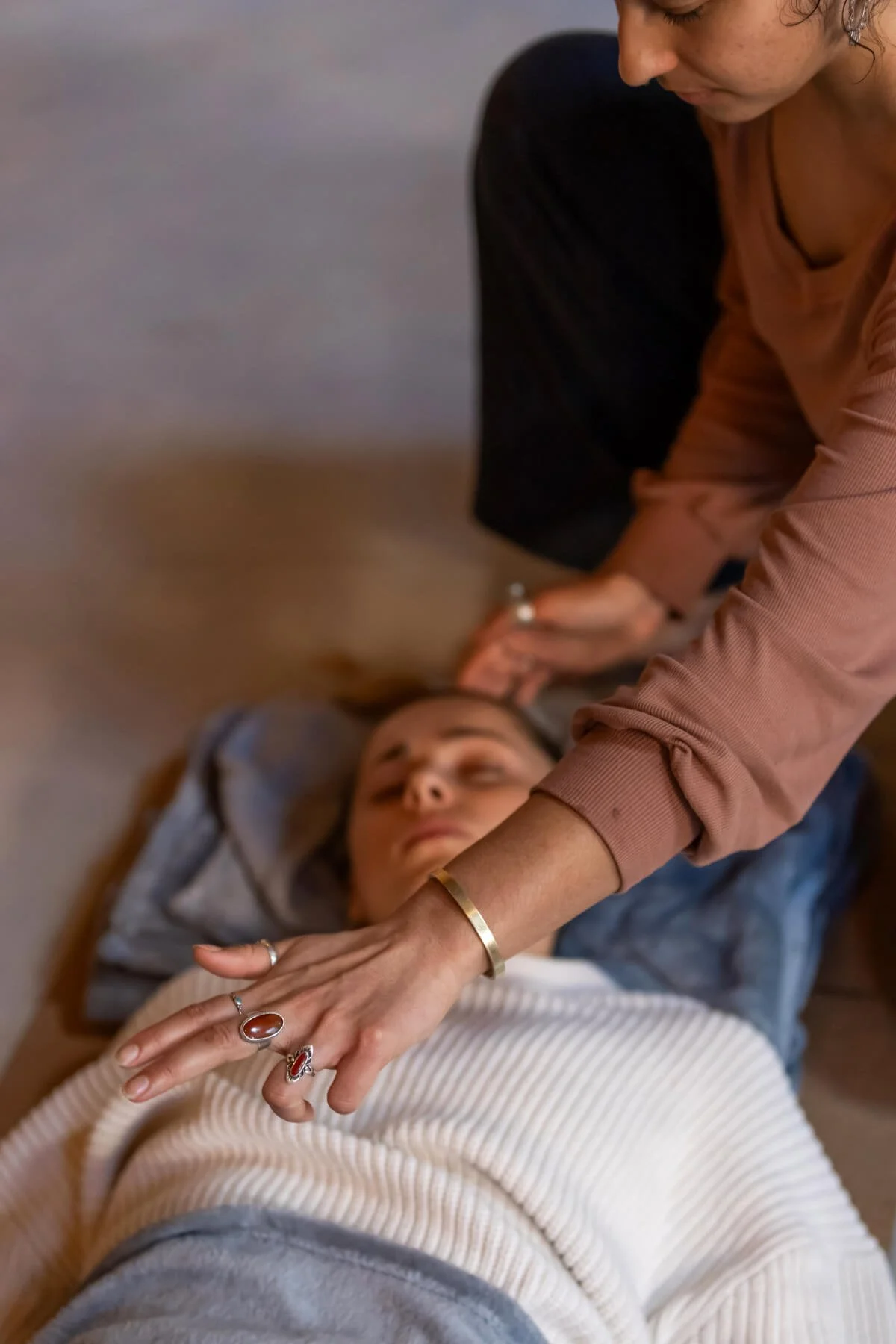 Woman on the yoga mat peacefully breathing with another woman next to her creating support