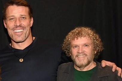 Tony Robbins is hugging Dan Brule