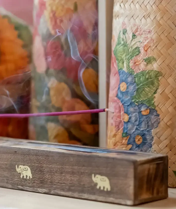 bali incence at Luv Yourself Space in London - a tray with incense sticks and clouds of smoke, and decorated paper bags with floral patterns in the background