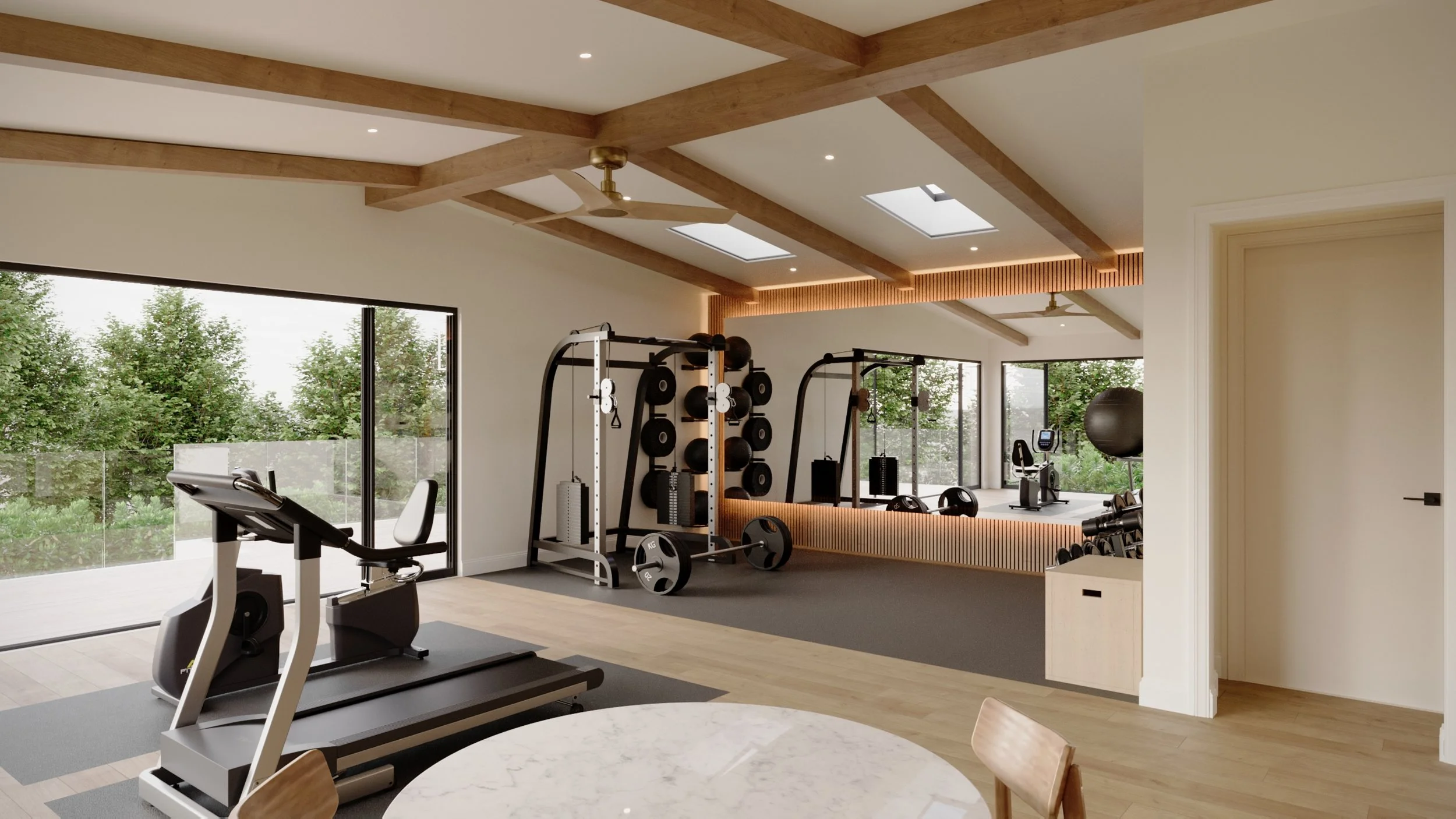 Home gym with treadmills, weight racks, and exercise equipment near large windows with a view of trees.