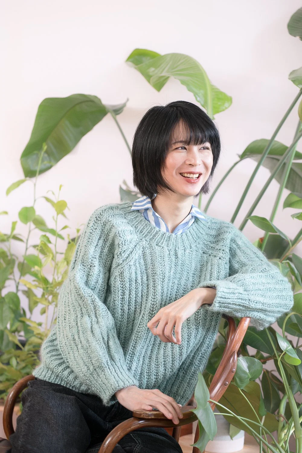 Wren Zhu counsellor sitting in front of plants, trauma counsellor in Vancouver