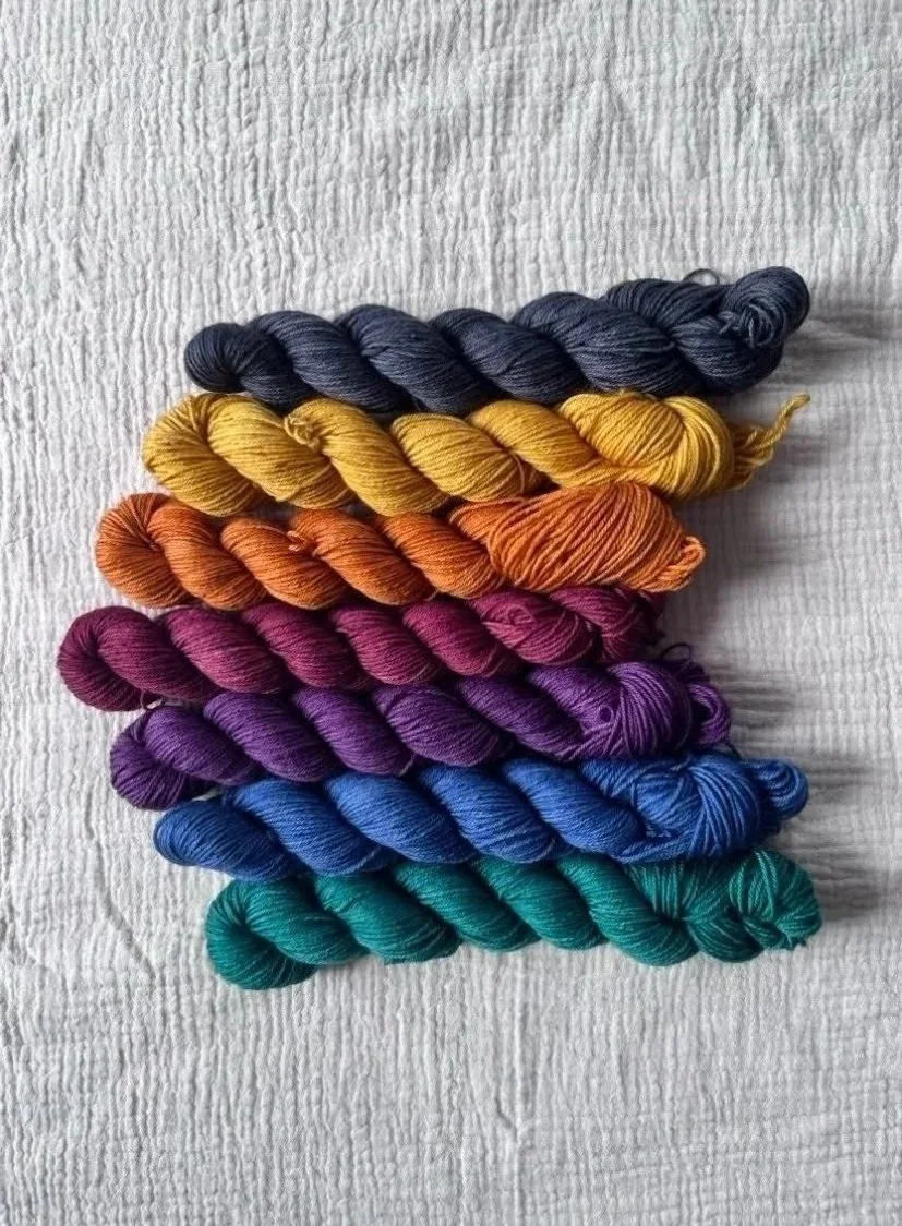7 mini skeins, green, blue, purple, red, orange, yellow, and black