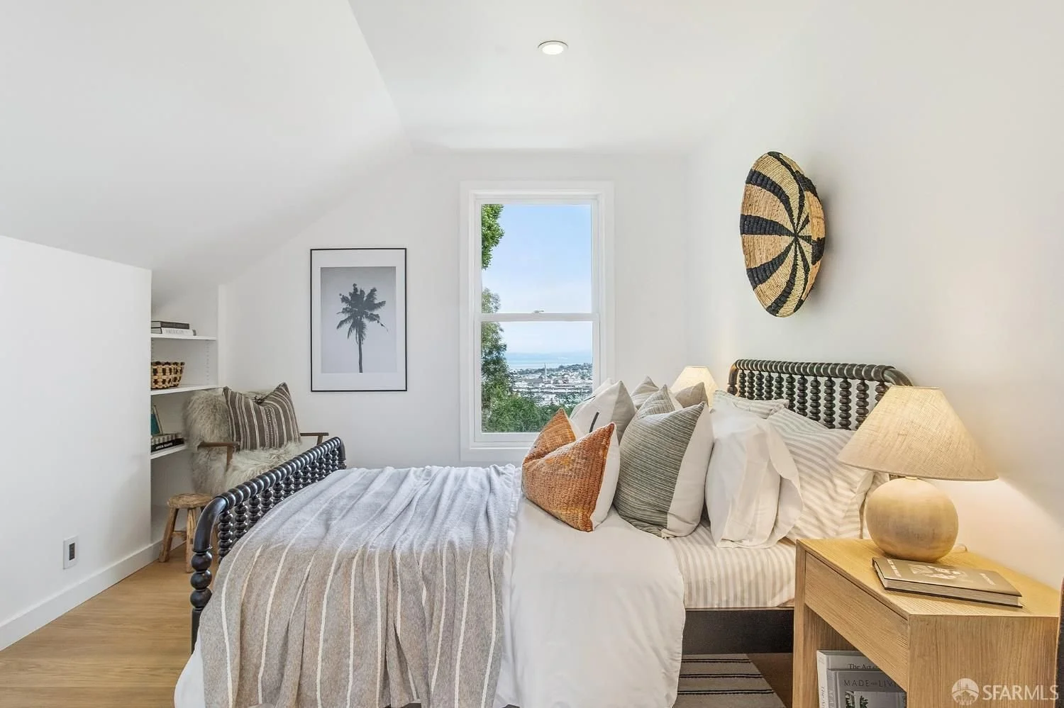 Living room with a fireplace, cream sofa, and built-in shelves, viewed from the dining area with a wooden table and chairs. Modern decor with plants, artwork, and wooden accents.