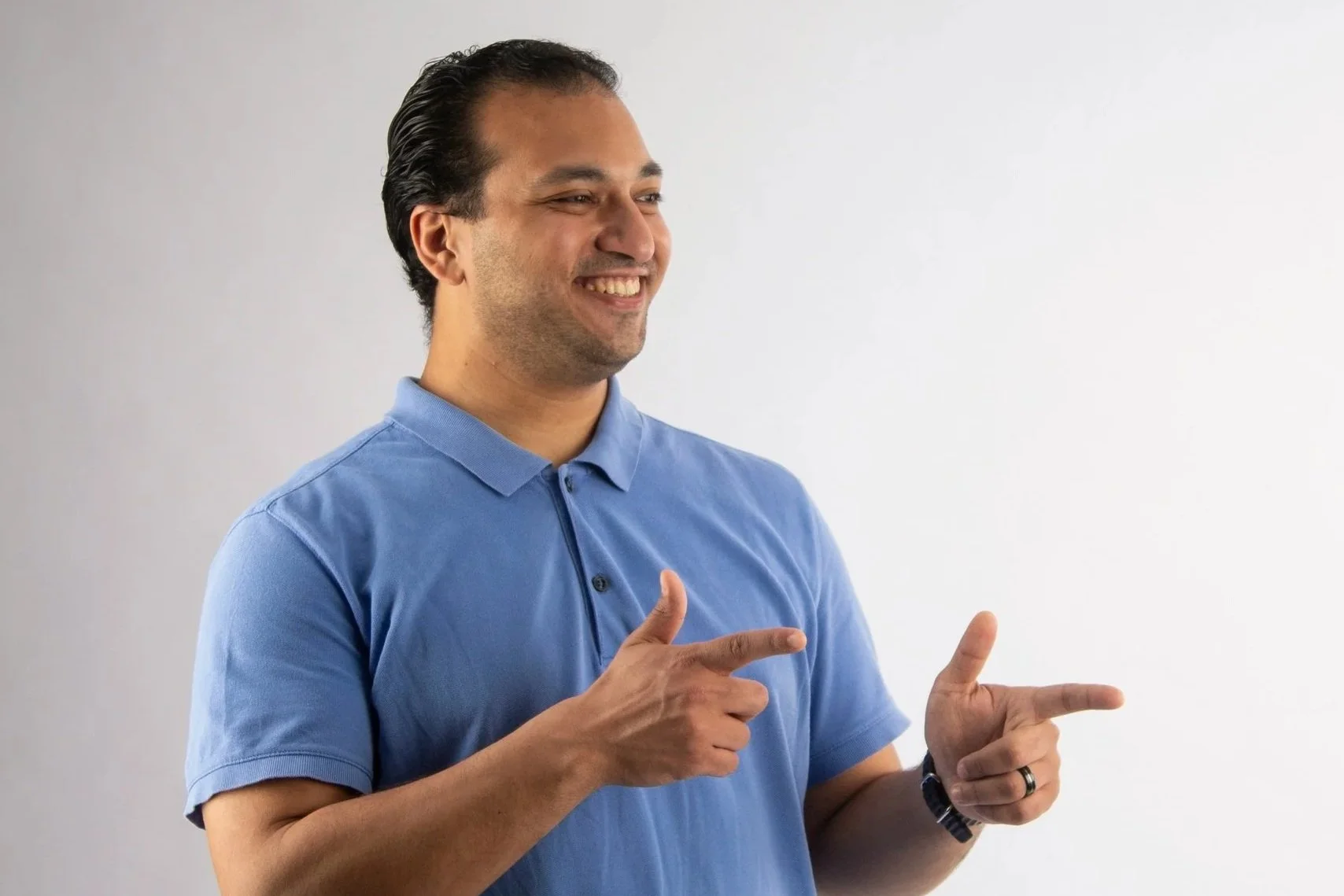 Scenic landscape with a lake, rolling green hills, and mountains under a cloudy sky.