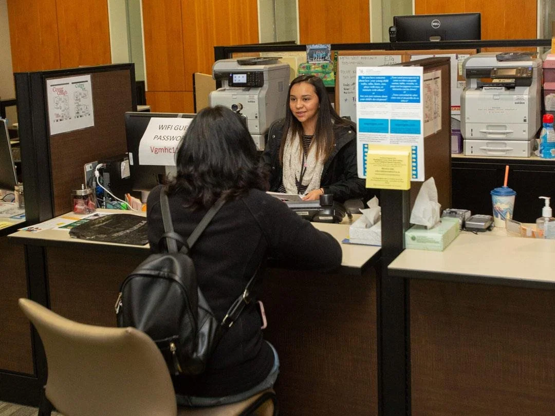 A patient sits with the receptionist at Virginia Garcia Memorial Health Center.