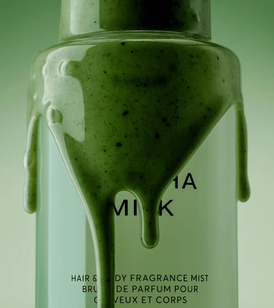 Matcha Milk by Phlur – hair and body fragrance mist bottle with dripping matcha texture, and bottle surrounded by bergamot and jasmine flowers, Coffee Break trend by WSSC